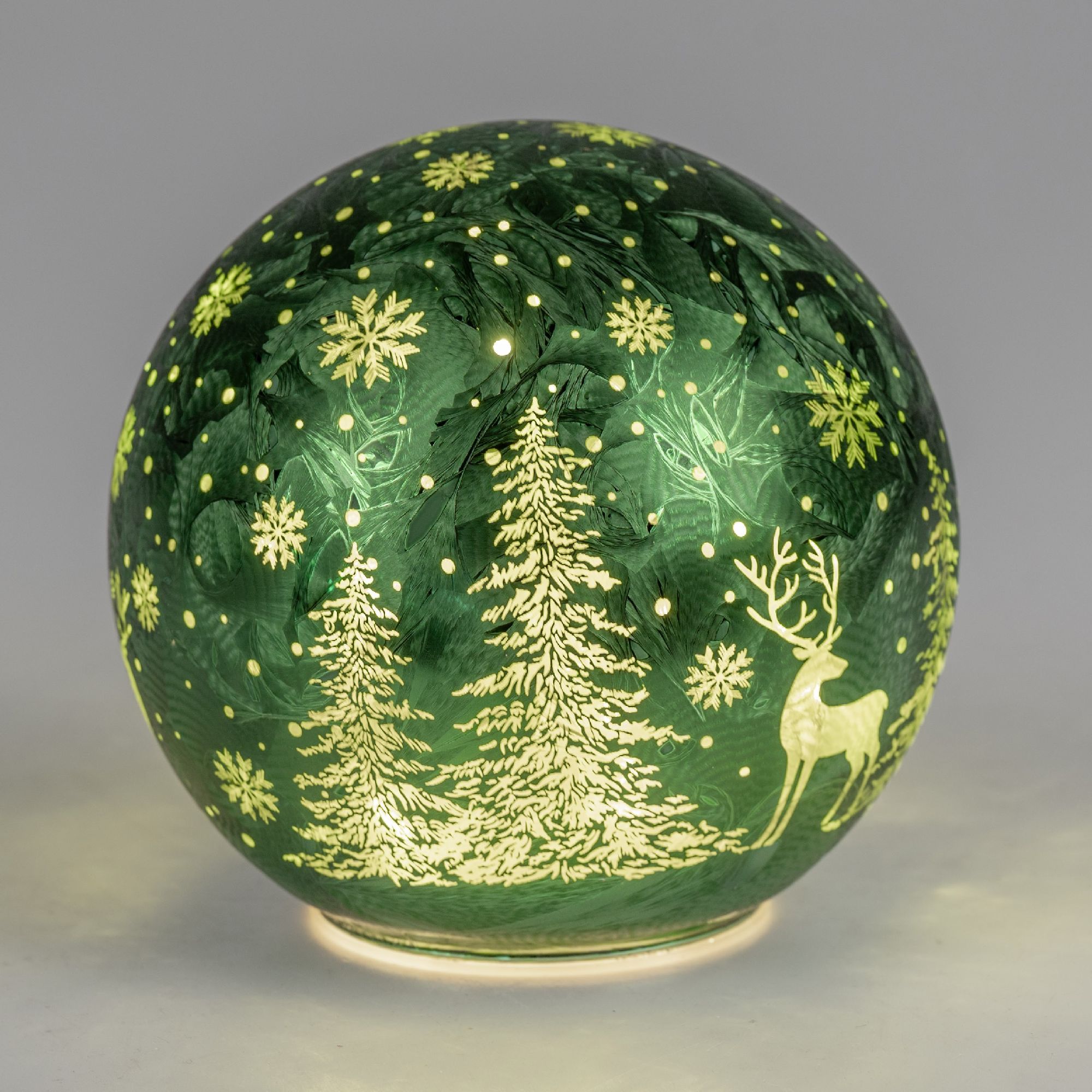 Grüne Weihnachtskugel mit goldenen Motiven von Tannenbäumen, Schneeflocken und einem Rentier auf ein