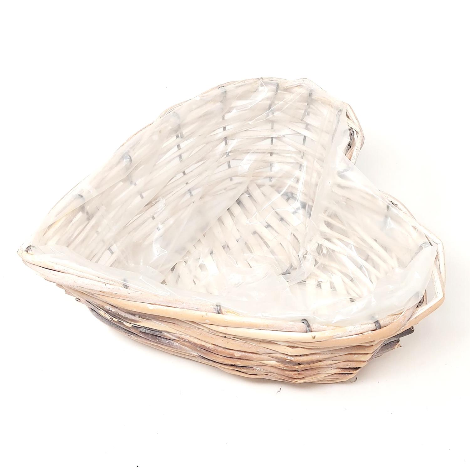 Ein herzförmiger Korb aus geflochtenem Material, teilweise mit durchsichtiger Folie umwickelt.