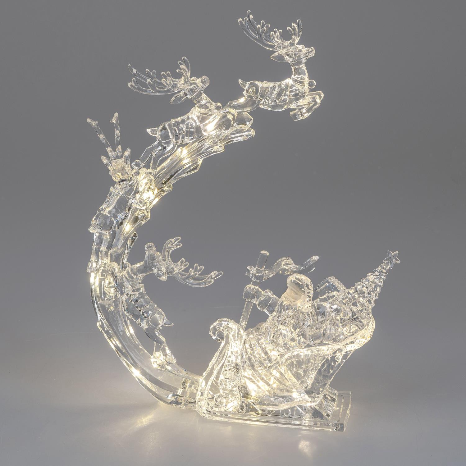 Durchsichtige Weihnachtsdekoration mit einem Schlitten, Rentieren und einem Weihnachtsbaum, beleucht