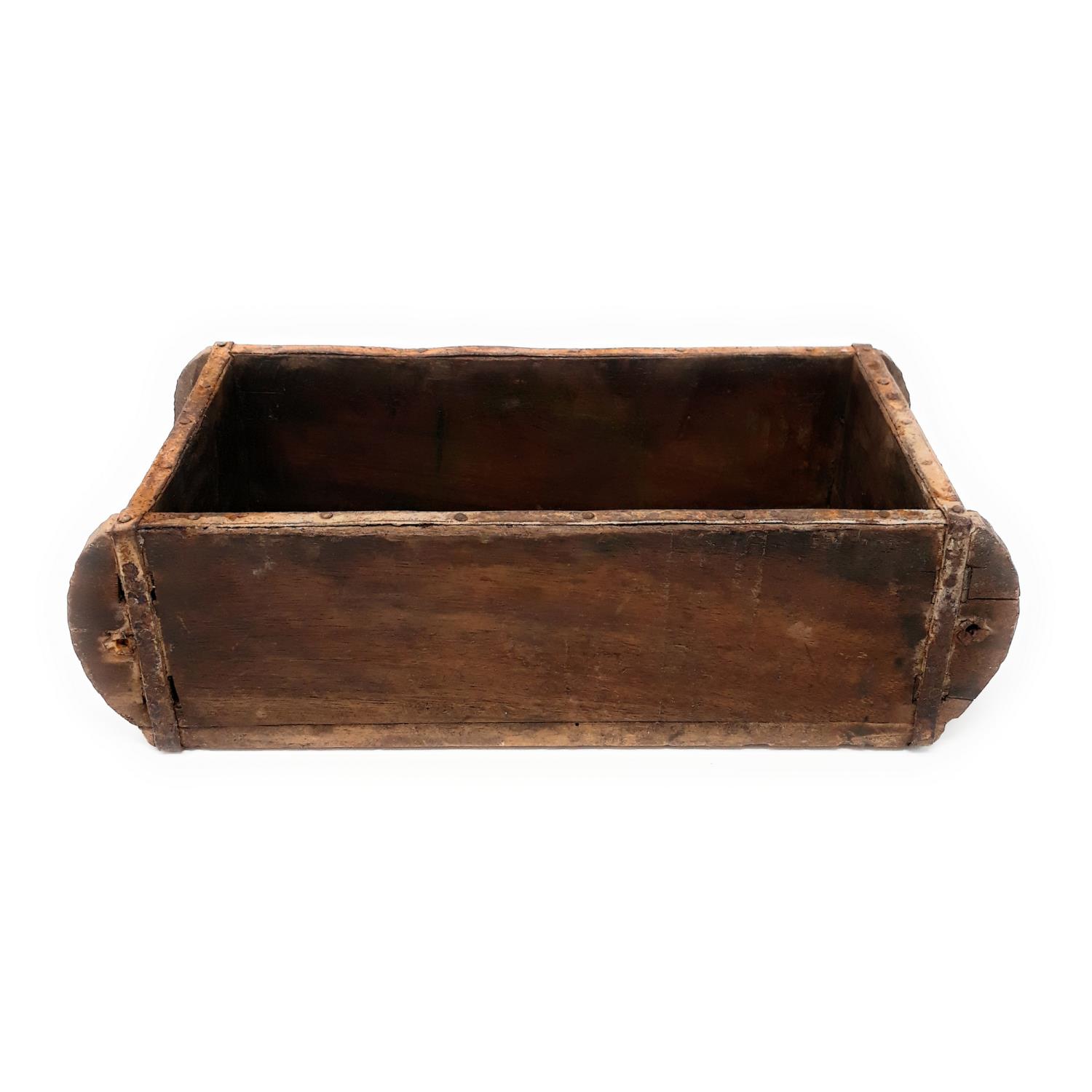Holzkiste mit rechteckiger Form, offen, ohne Deckel, aus dunklem Holz, mit sichtbaren Gebrauchsspuren und abgerundeten Ecken.