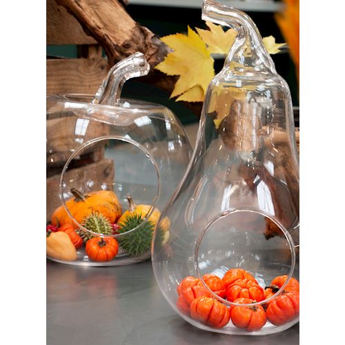 Zwei transparente Glasbehälter in Form von Kürbissen, gefüllt mit verschiedenen herbstlichen Früchten und Dekorationen.