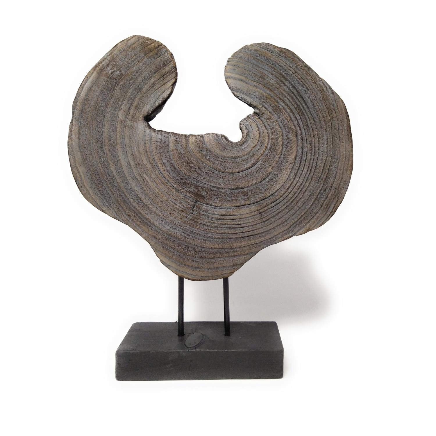Holzskulptur auf schwarzem Sockel, mit geschwungener Form und sichtbaren Jahresringen.