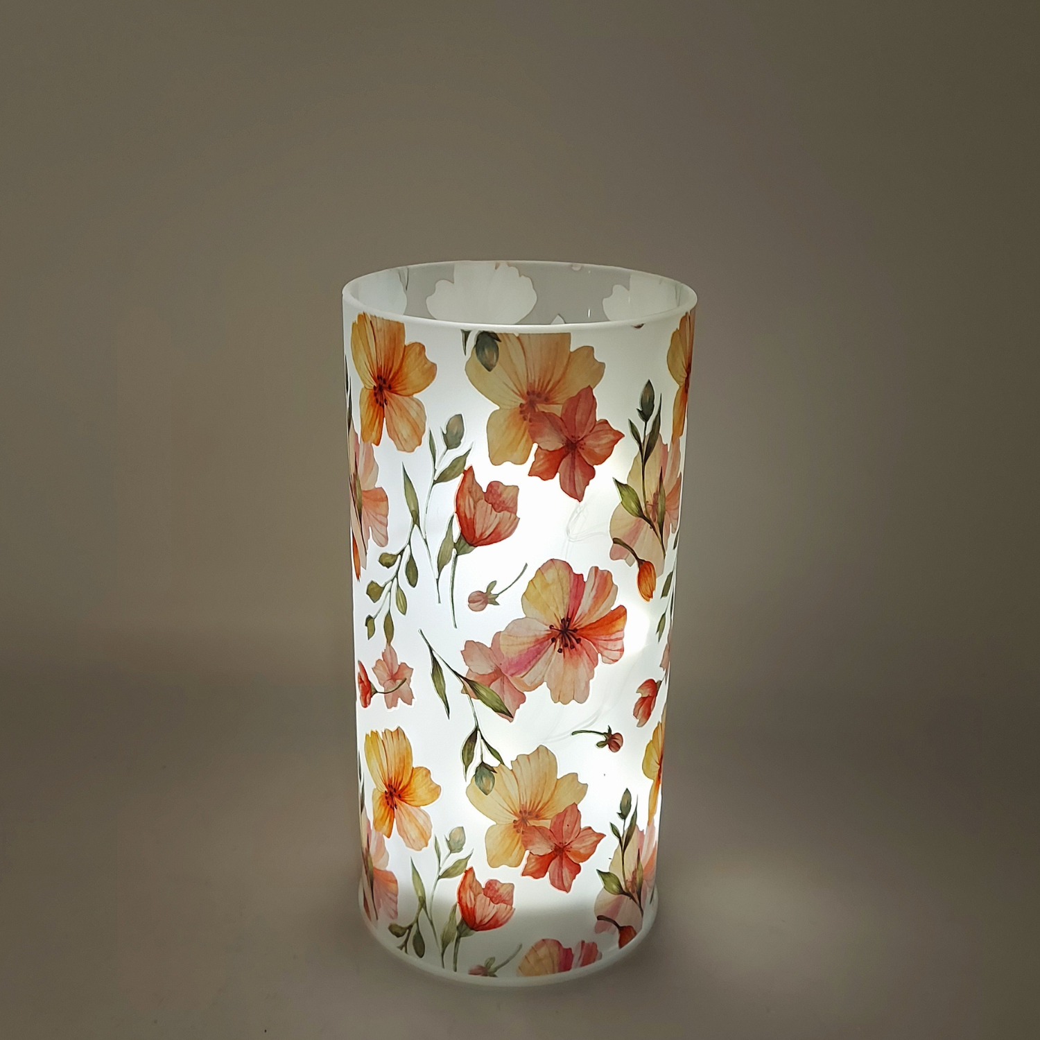 weiß transparenter Zylinder mit Blumen Motiv beleuchtet auf schwarzem Hintergrund