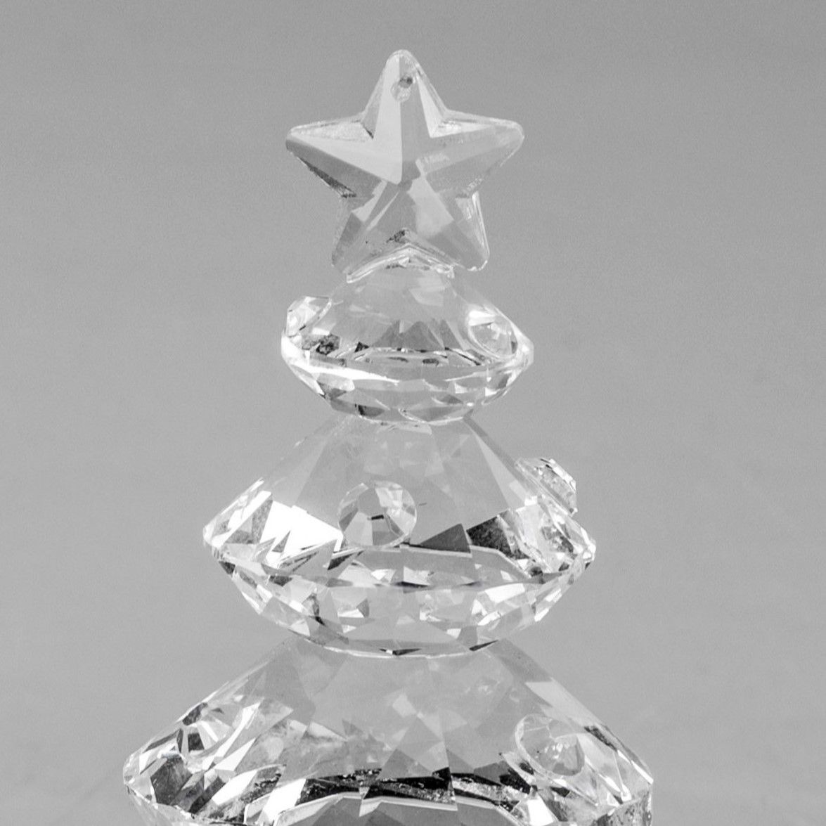 Kristallbaum mit einer sternförmigen Spitze, bestehend aus mehreren transparenten, facettierten Elem