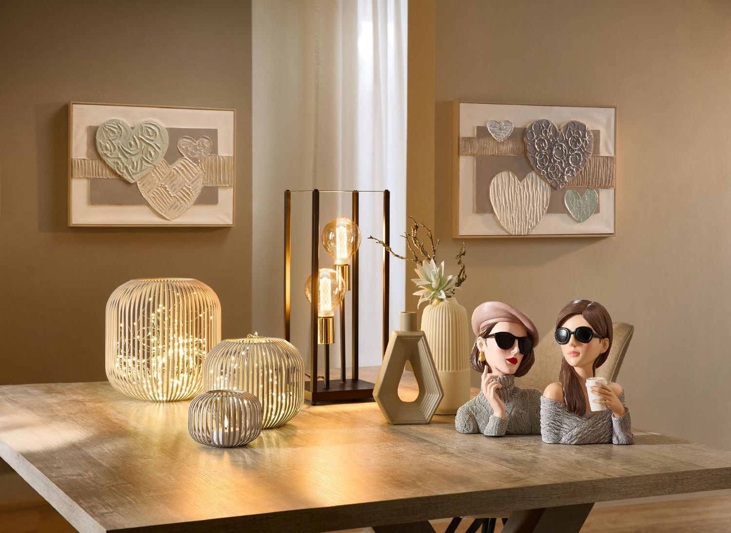 Zwei Figuren mit Sonnenbrillen sitzen an einem Tisch. Im Hintergrund sind Bilder mit Herzmotiven und verschiedene Leuchten zu sehen.