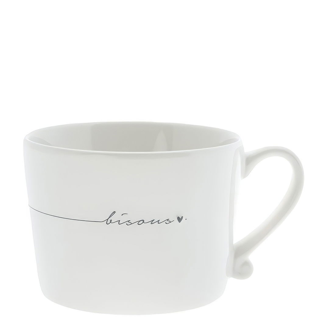Weiße Tasse mit einem geschwungenen Schriftzug "bisous" und einem kleinen Herz. Die Tasse hat einen Henkel.