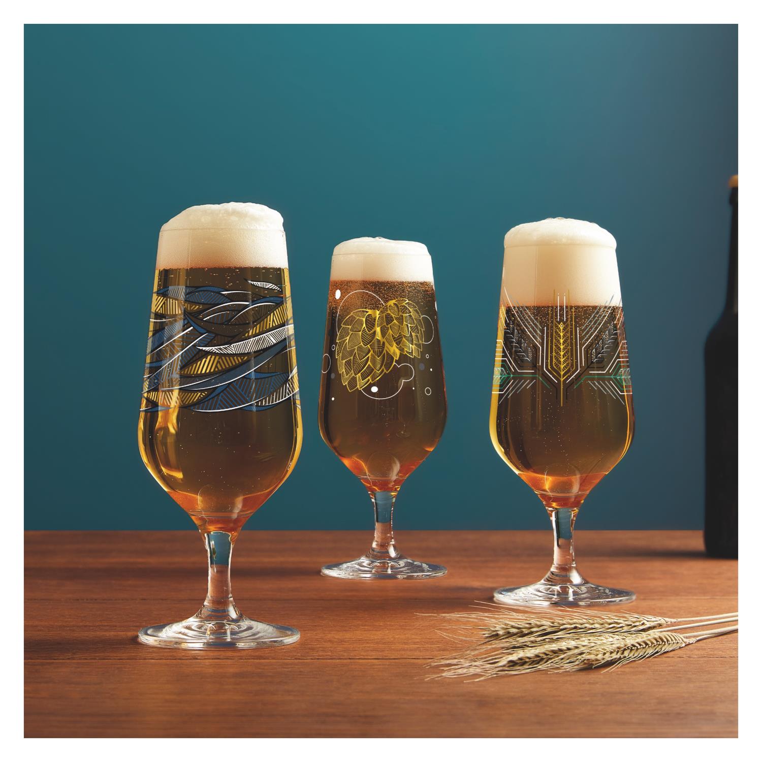 Drei Gläser mit Bier stehen auf einem Holztisch. Jedes Glas hat ein einzigartiges, farbiges Muster. Im Hintergrund eine grüne Wand.