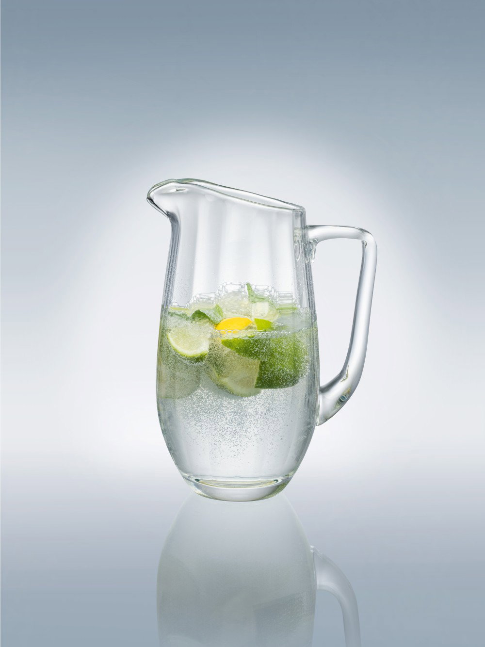 Verpackung eines Glaskrugs mit Wasser, Limetten und Eis sowie einem weiteren Getränk in einem anderen Krug.