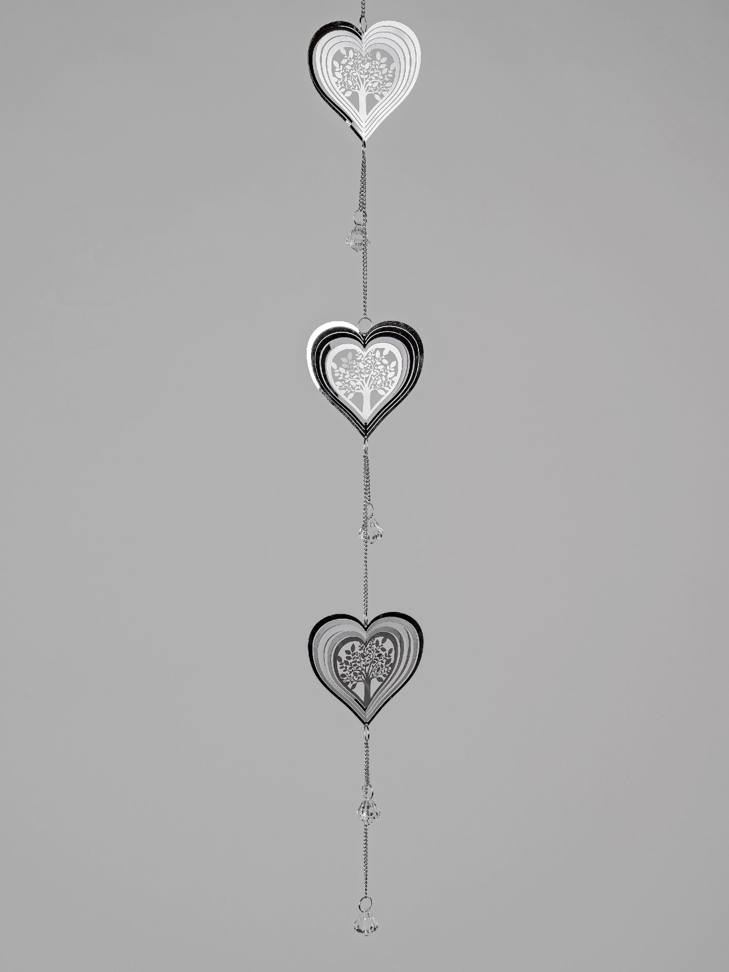Drei hängende Herzen aus Papier in Schwarz und Weiß, mit filigranen Mustern, an einer Kette befestig