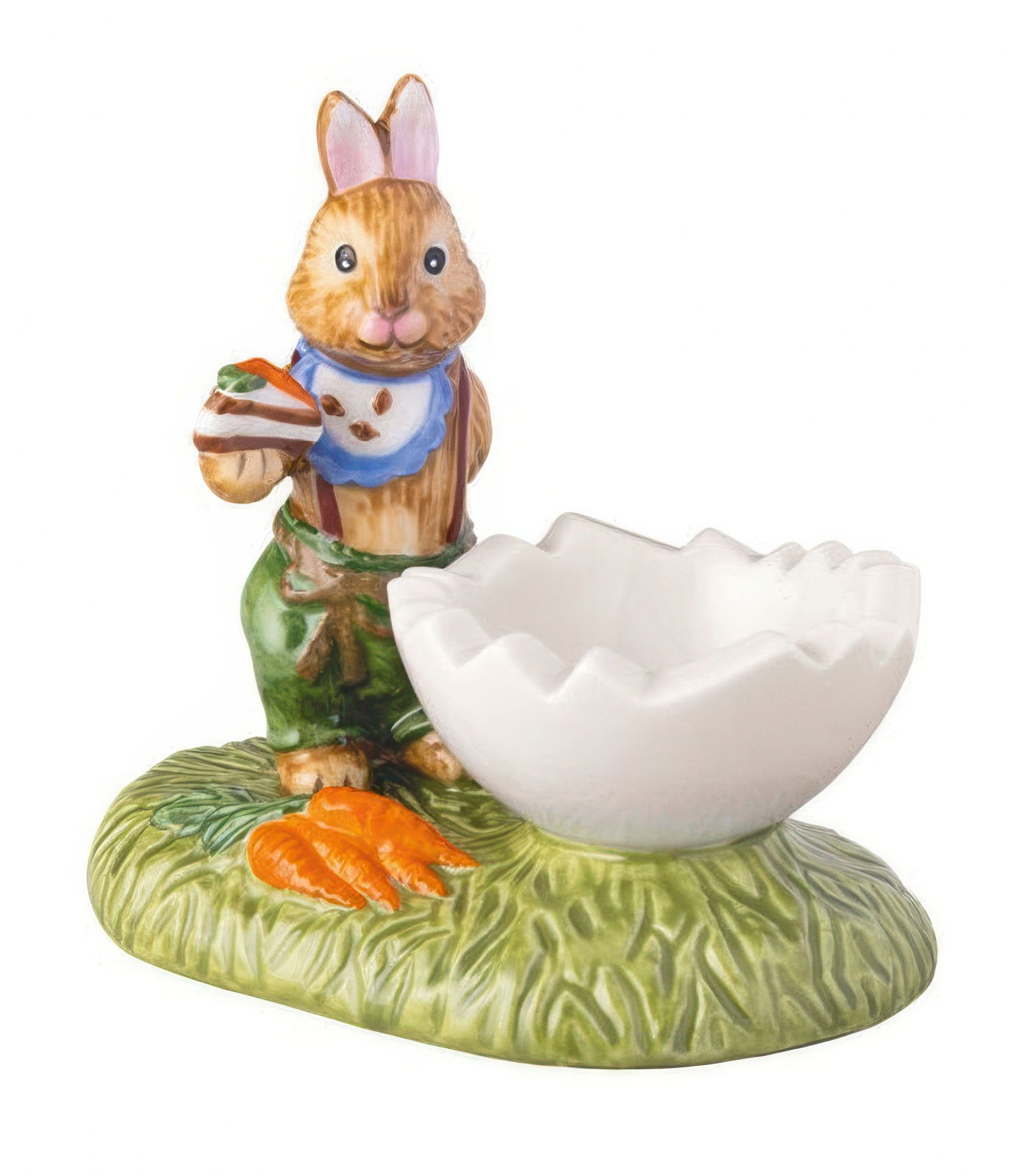 Ein keramischer Hase mit Karotten steht neben einer weißen, schalenförmigen Eierhalterung auf einer grünen Unterlage.