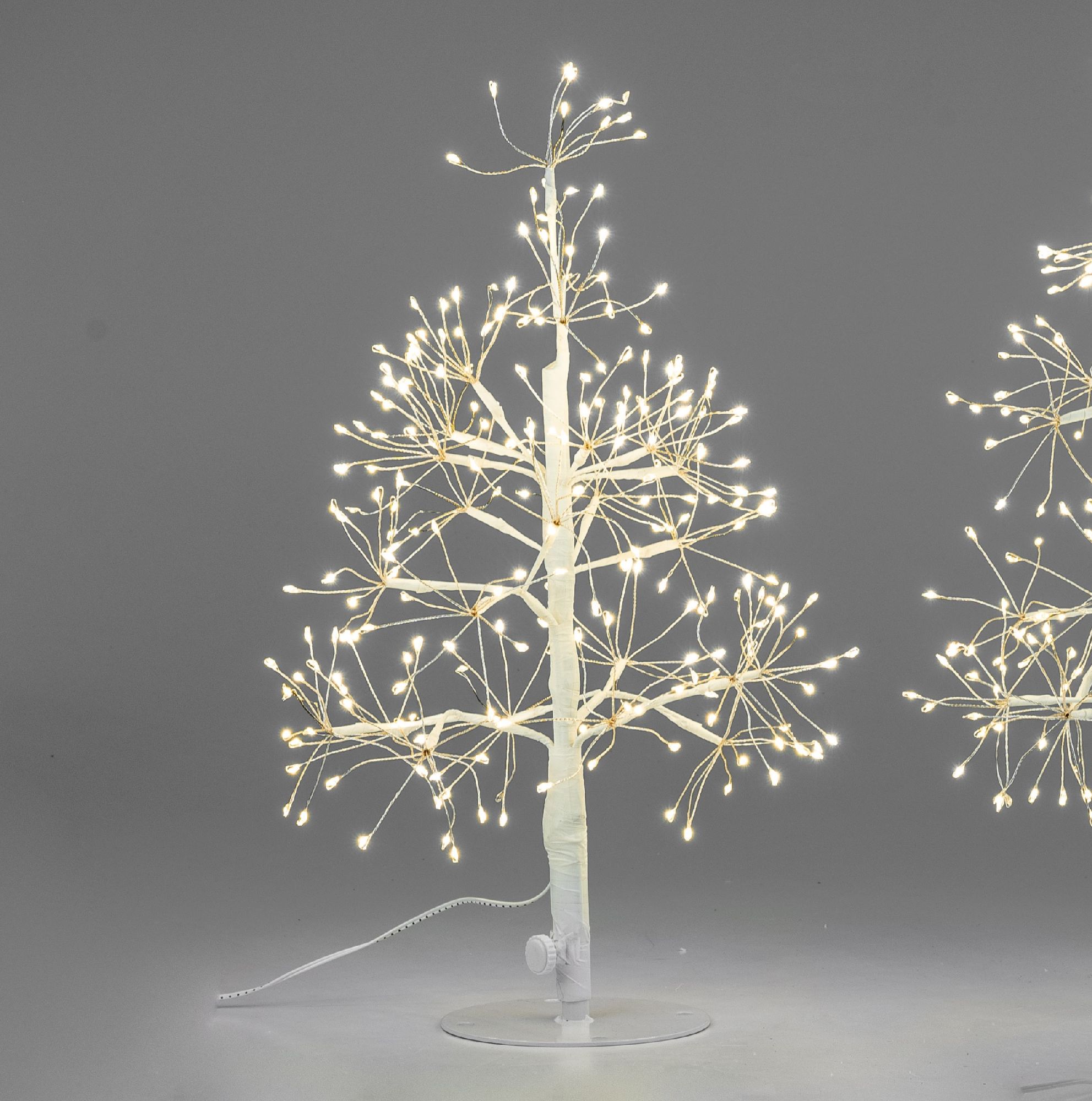 Ein dekorativer Baum mit leuchtenden Zweigen auf grauem Hintergrund