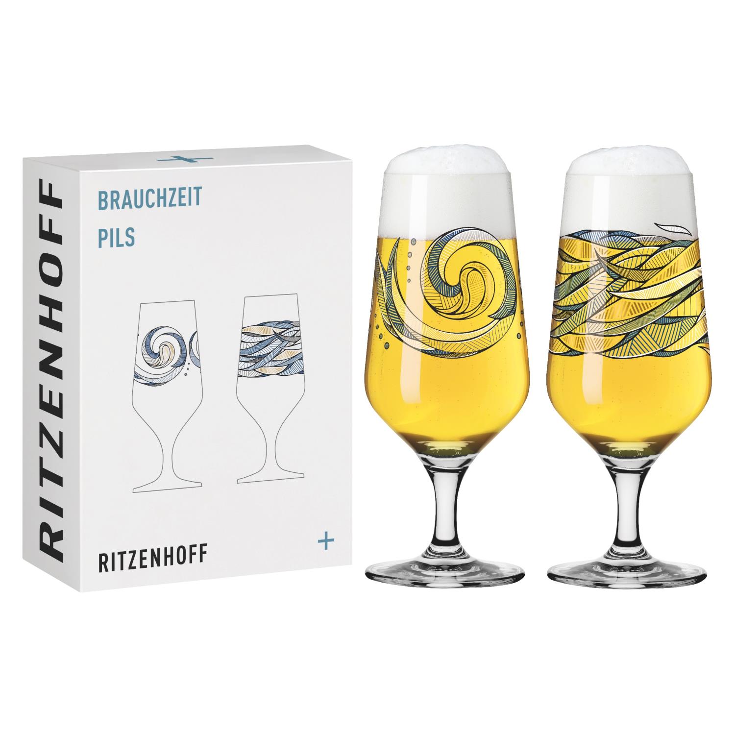 Zwei dekorative Biergläser mit unterschiedlichen Mustern, gefüllt mit hellem Bier und Schaum, neben einer Verpackung.