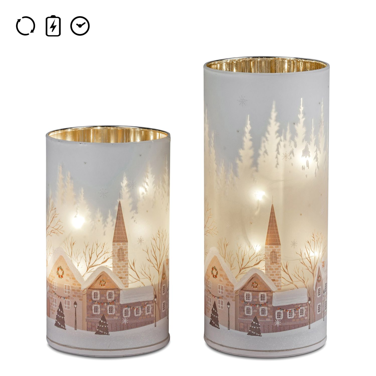 Zwei leuchtende Glaszylinder mit winterlichem Dorfmotiv und Tannen im Hintergrund