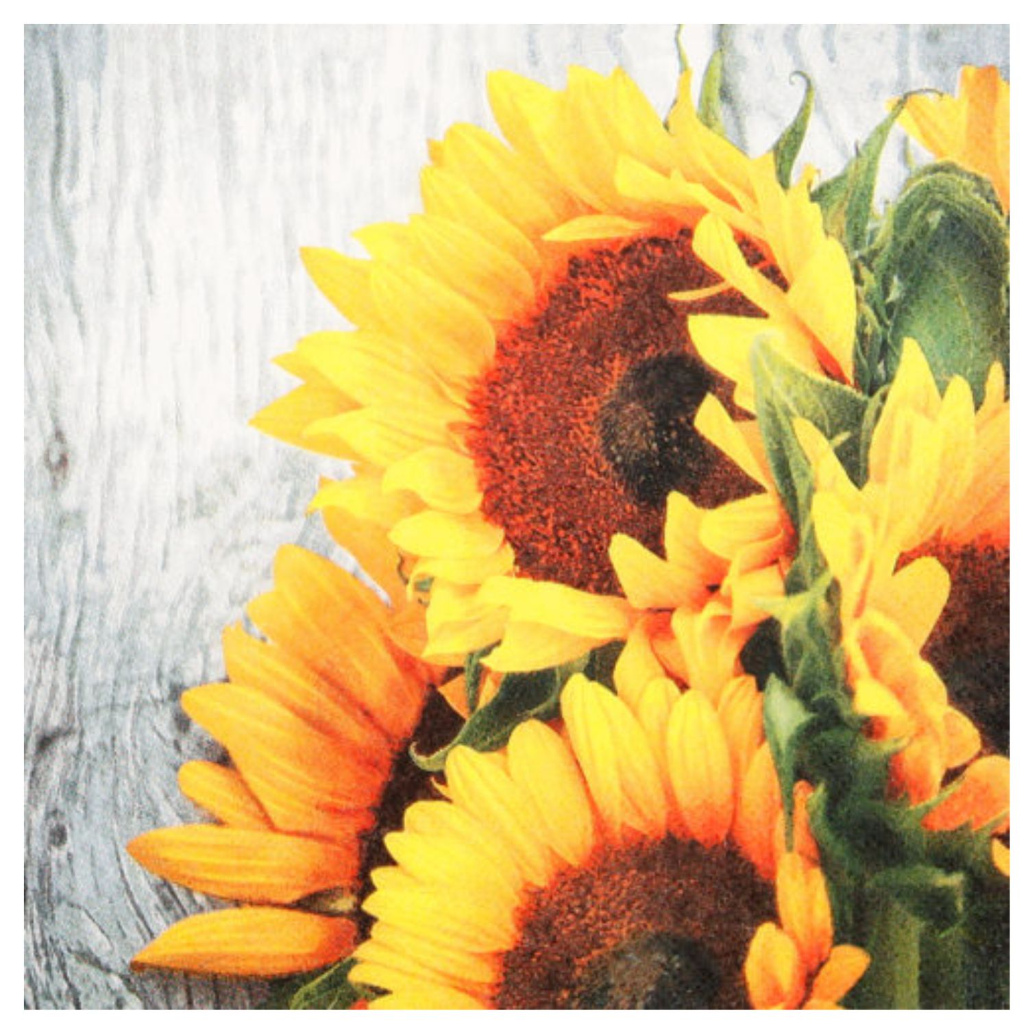 Ein Strauß aus leuchtend gelben Sonnenblumen vor einer hellen Holzoberfläche.