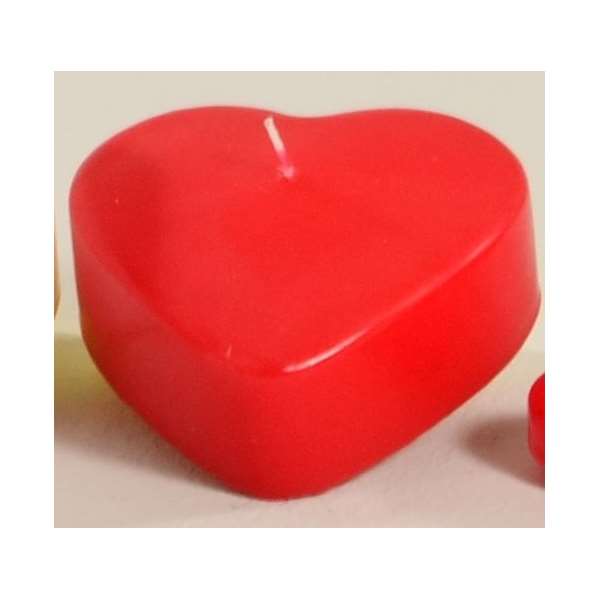 Rote Herzkerze auf einem hellen Untergrund, mit einer kleinen Dochtöffnung in der Mitte.