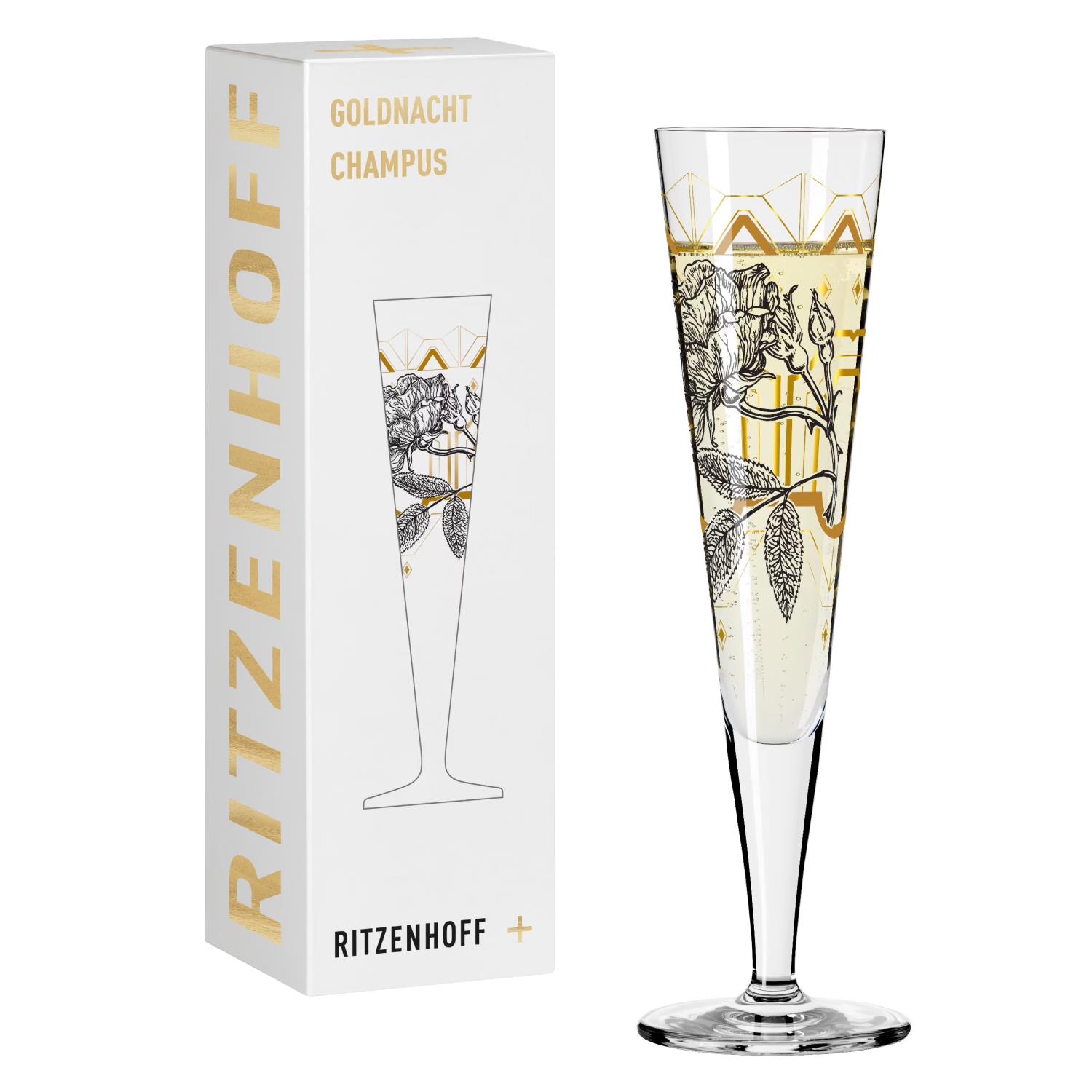 Ein schlanker Sektglas mit floralem Design steht neben einer weißen Verpackung mit goldener Schrift.