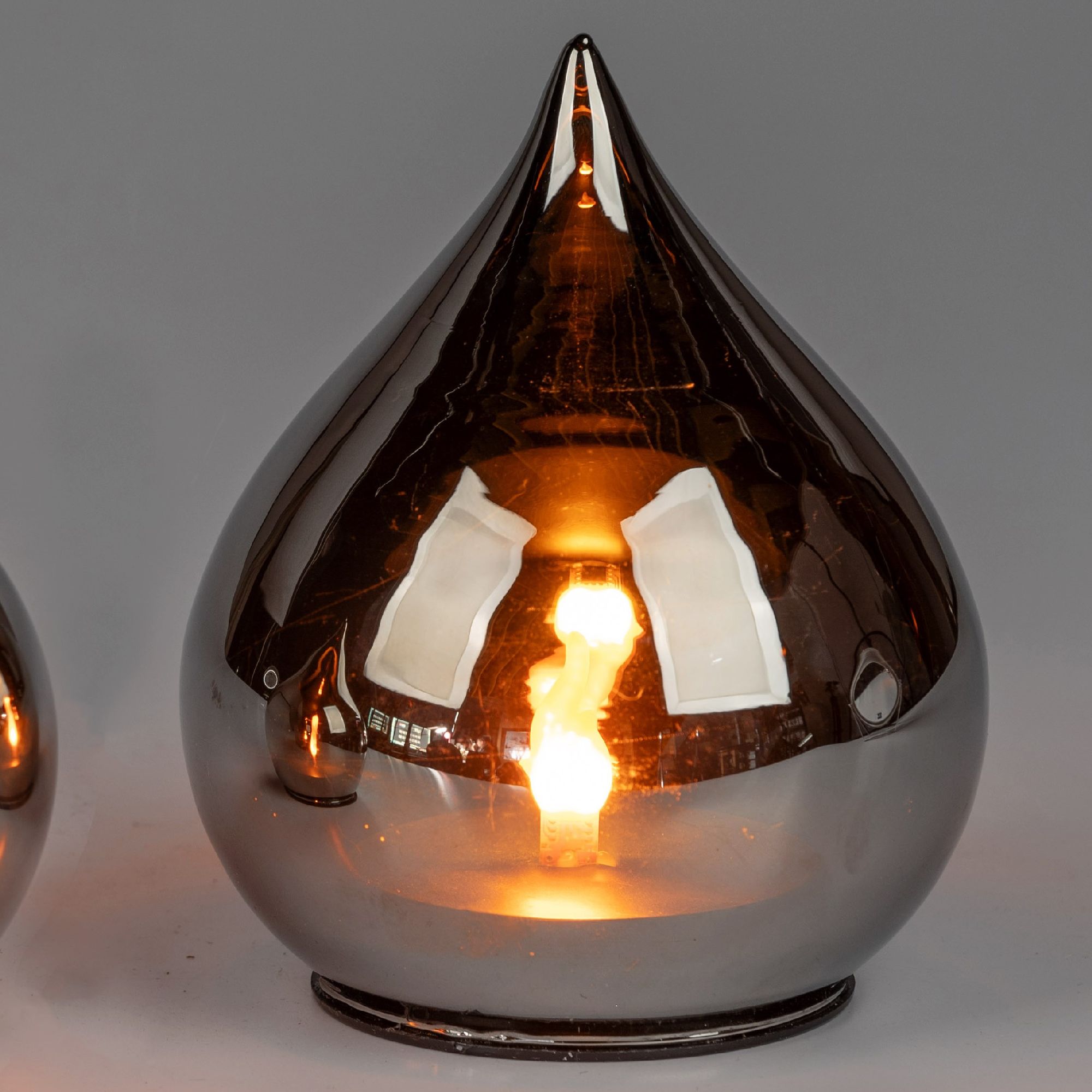 Glänzende Lampe in Tropfenform mit sichtbarem Lichtschein