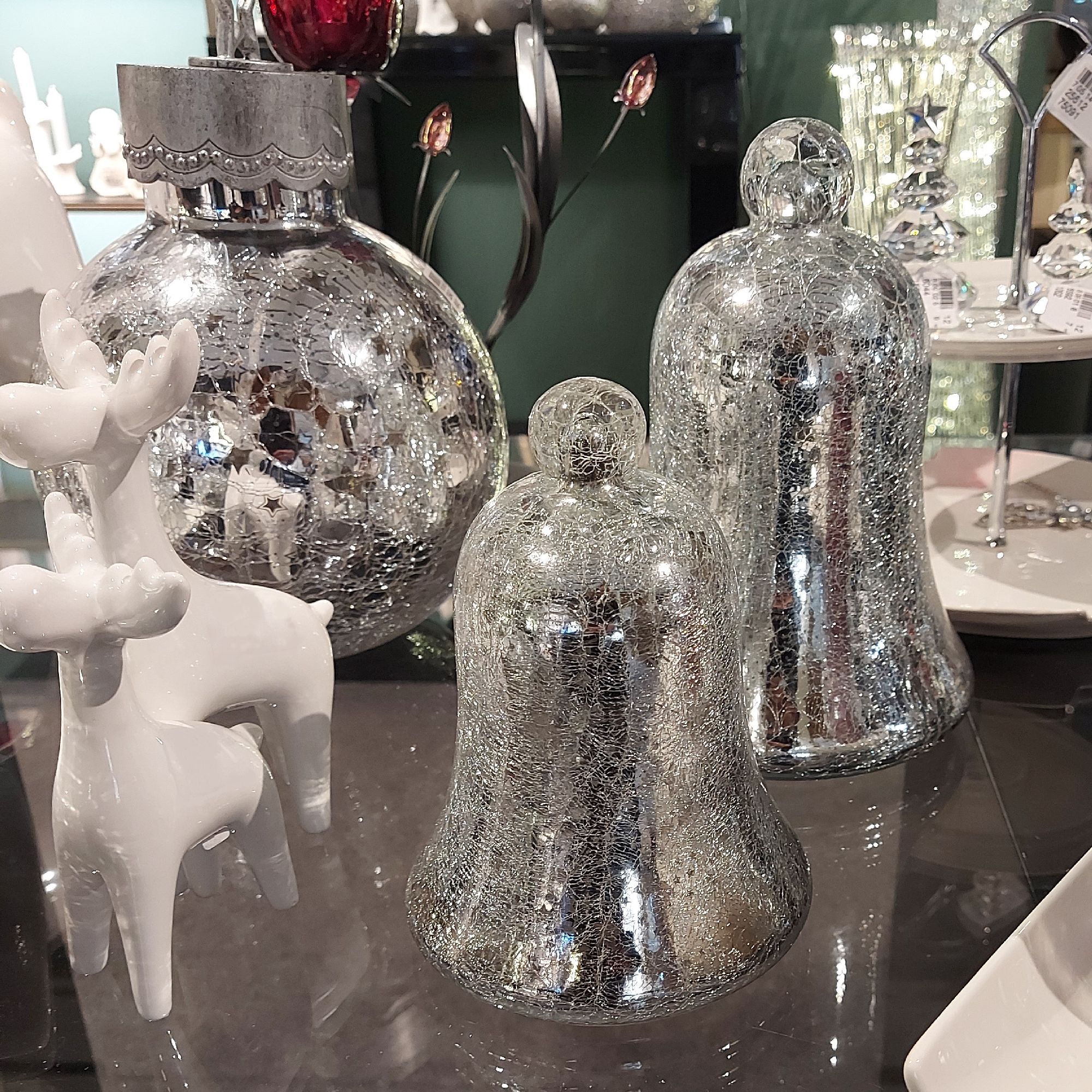 Dekorative Objekte: zwei gläserne Glocken, ein runder, spiegelnder Behälter und ein weißes Rentier a