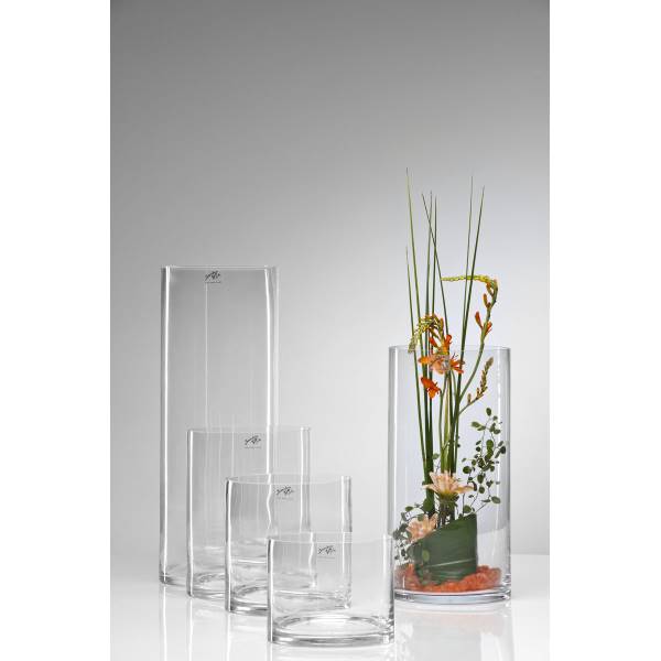 Vier transparente Vasen in verschiedenen Größen, eine mit bunten Blumen und grünen Pflanzen dekoriert. Hintergrund hellgrau.