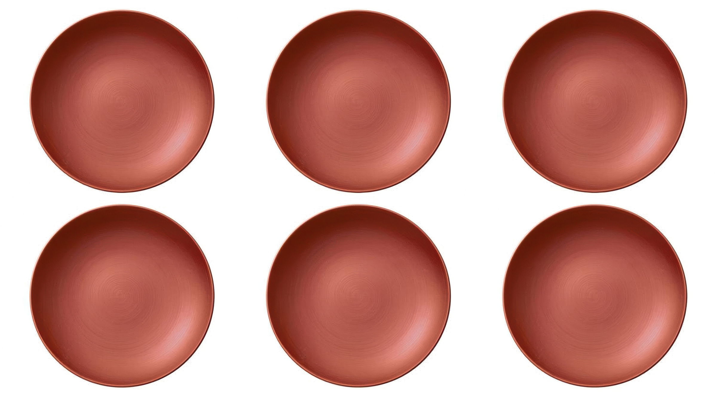 Sechs runde, flache Teller in einem einheitlichen, matten Rotton, gleichmäßig angeordnet.