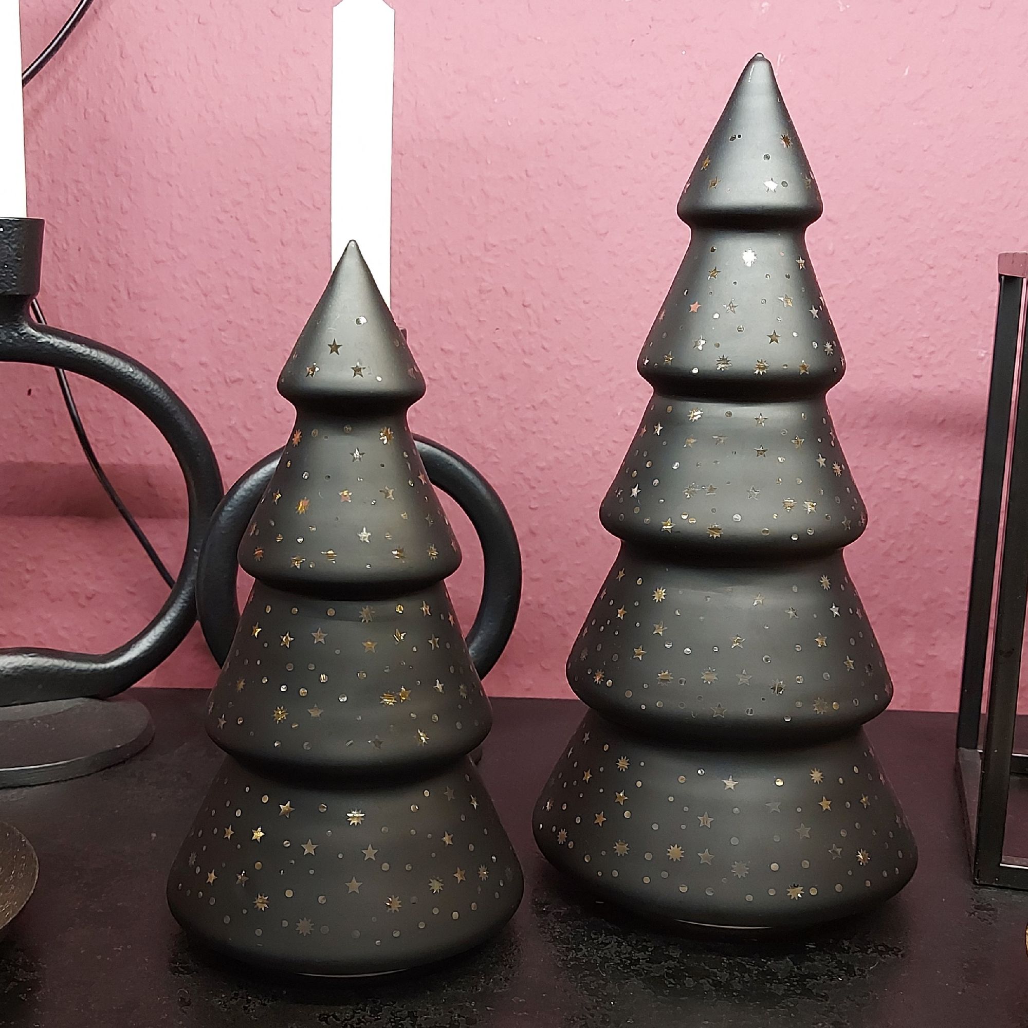 Zwei schwarze LED Weihnachtsbäume mit Sternenmotiv in zwei Größen auf schwarzem Regal