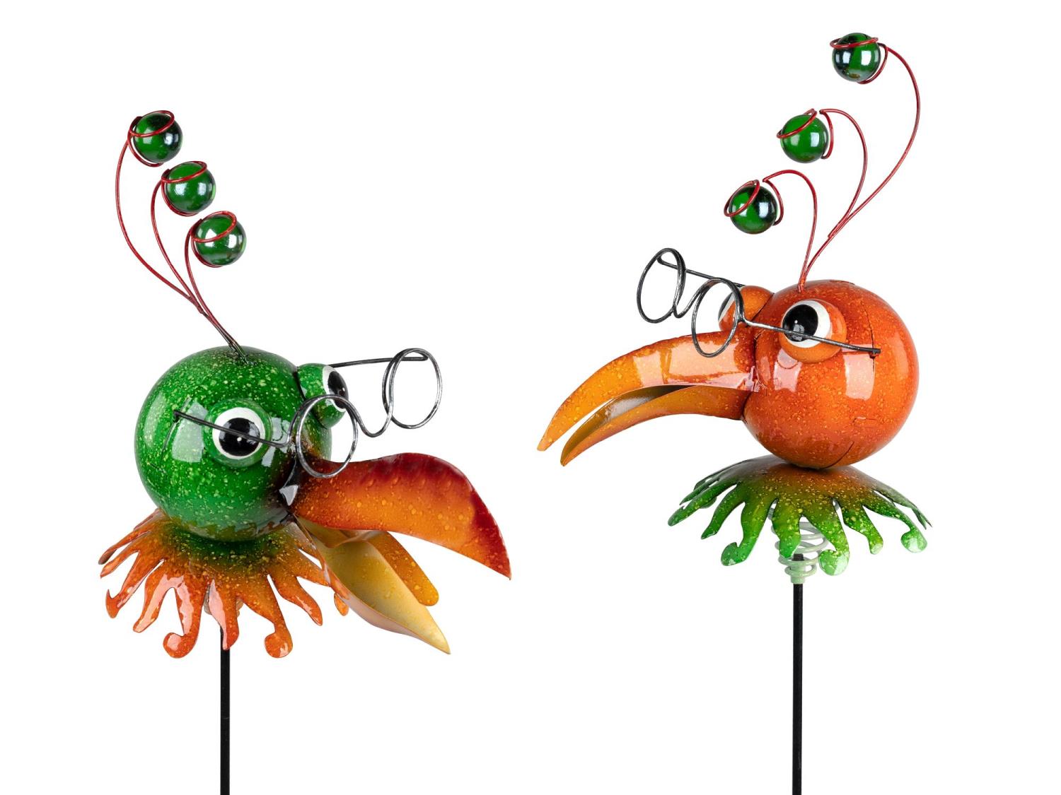 Zwei bunte Vogelskulpturen aus Glas, eine grün und eine orange, mit Brillen und auffälligen, geschwu