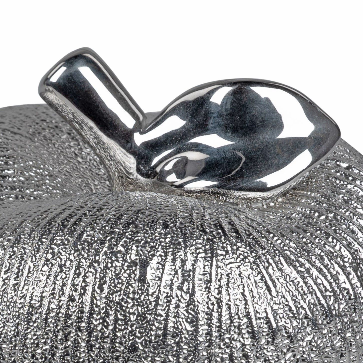 Silberner Apfel mit glänzendem Stiel und Blatt, Oberfläche mit feiner Struktur.