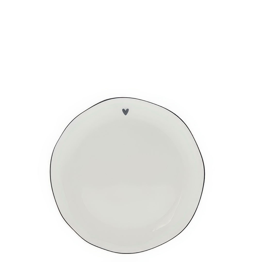 Ein runder, weißer Teller mit unregelmäßigem Rand und einem kleinen schwarzen Herzmotiv oben.