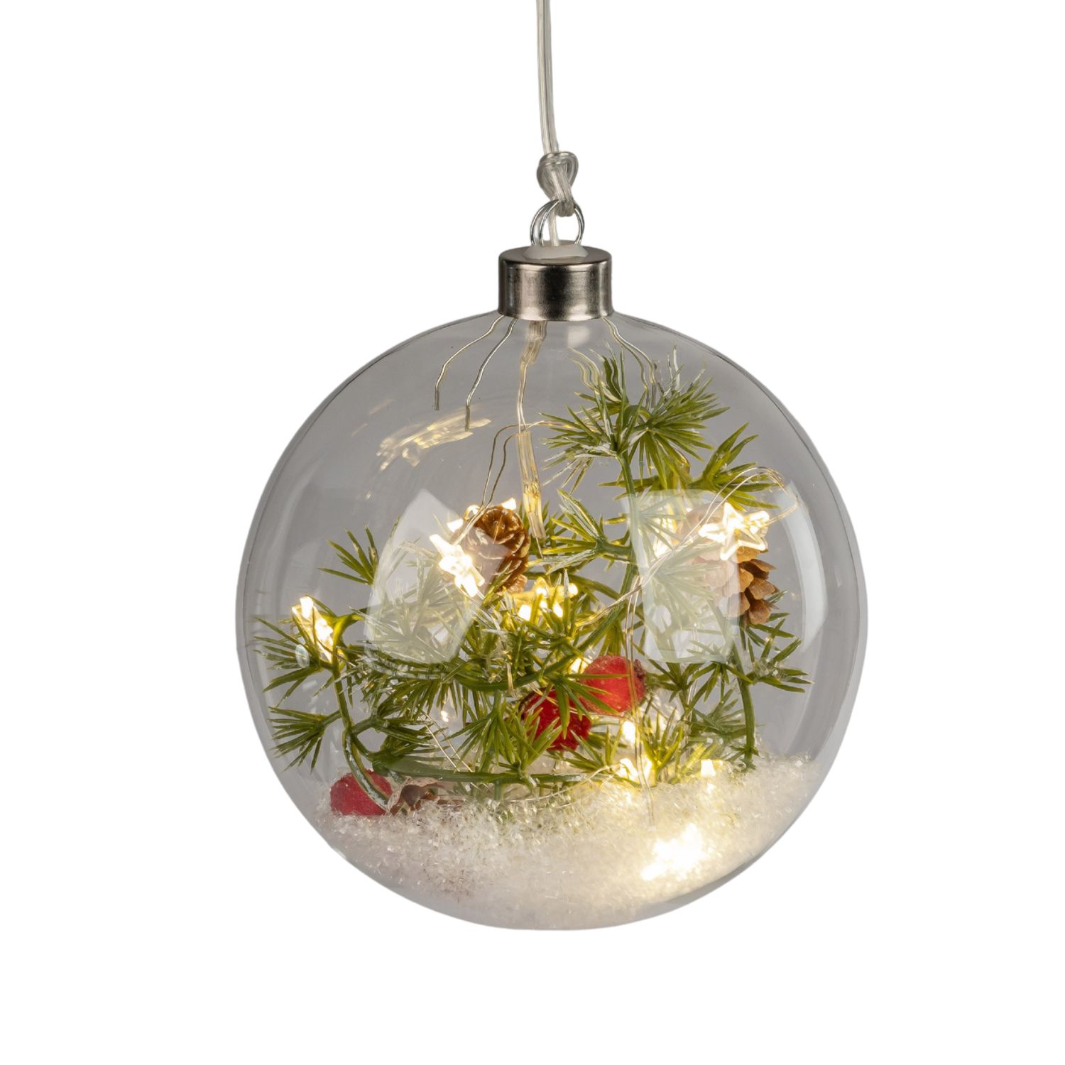 Glaskugel mit künstlichem Schnee, Tannenzweigen, roten Beeren und warmen Lichtern