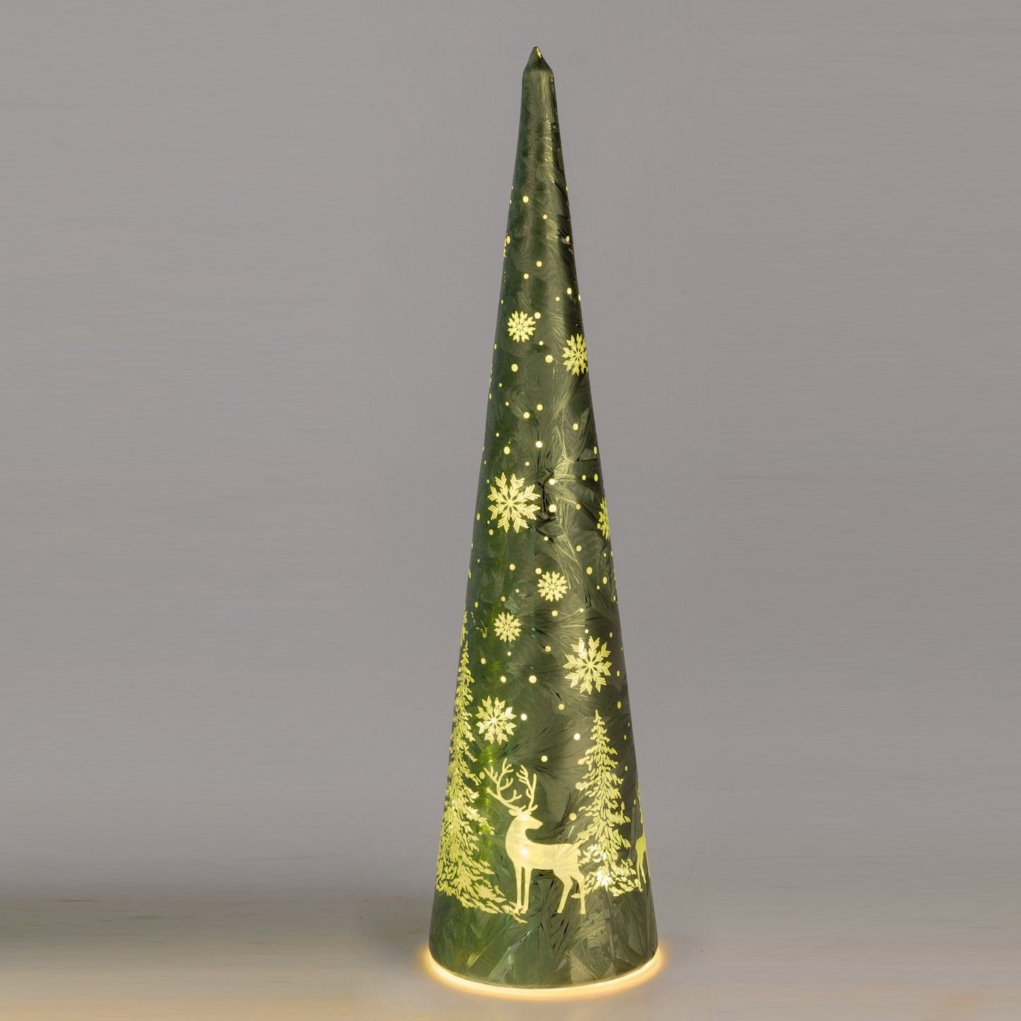 Grüner, spitz zulaufender Weihnachtsbaum aus Papier mit Schneeflocken und einem Reh, beleuchtet von