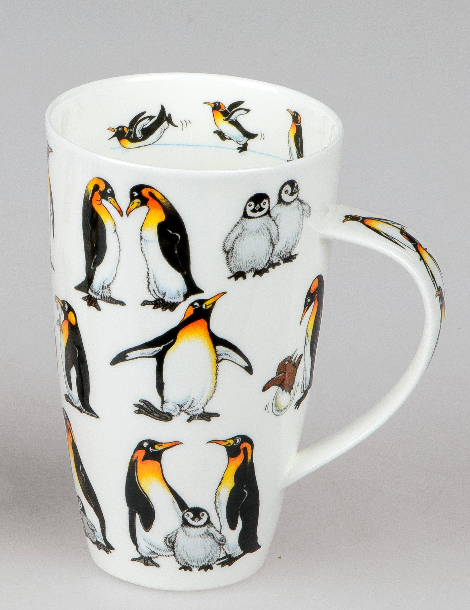 Weißer Becher mit bunten Pinguin-Motiven, darunter erwachsene Pinguine und Küken in verschiedenen Posen.