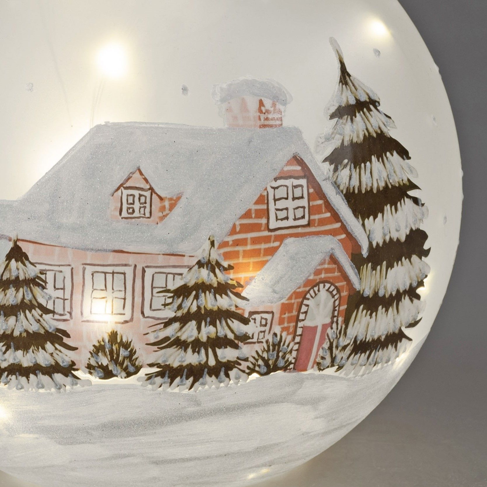 Eine winterliche Szene mit einem roten Backsteinhaus, umgeben von schneebedeckten Tannenbäumen und e