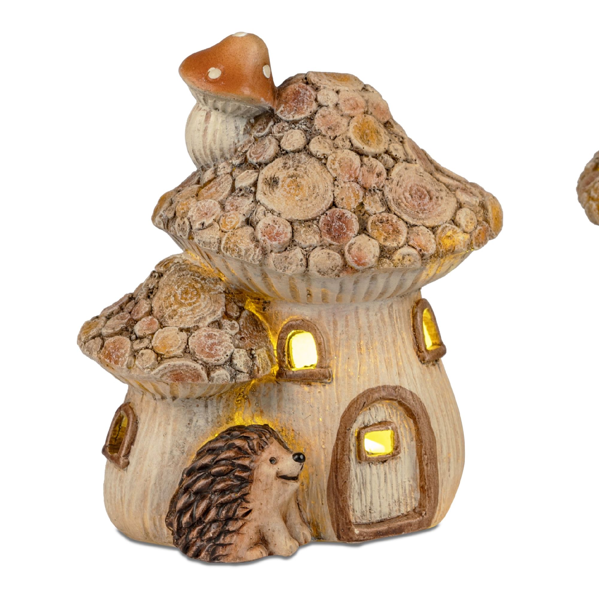 Eine kleine, pilzförmige Hausfigur aus Keramik mit einem Igel davor. Das Dach ist mit Holzscheiben verziert und hat Fenster.