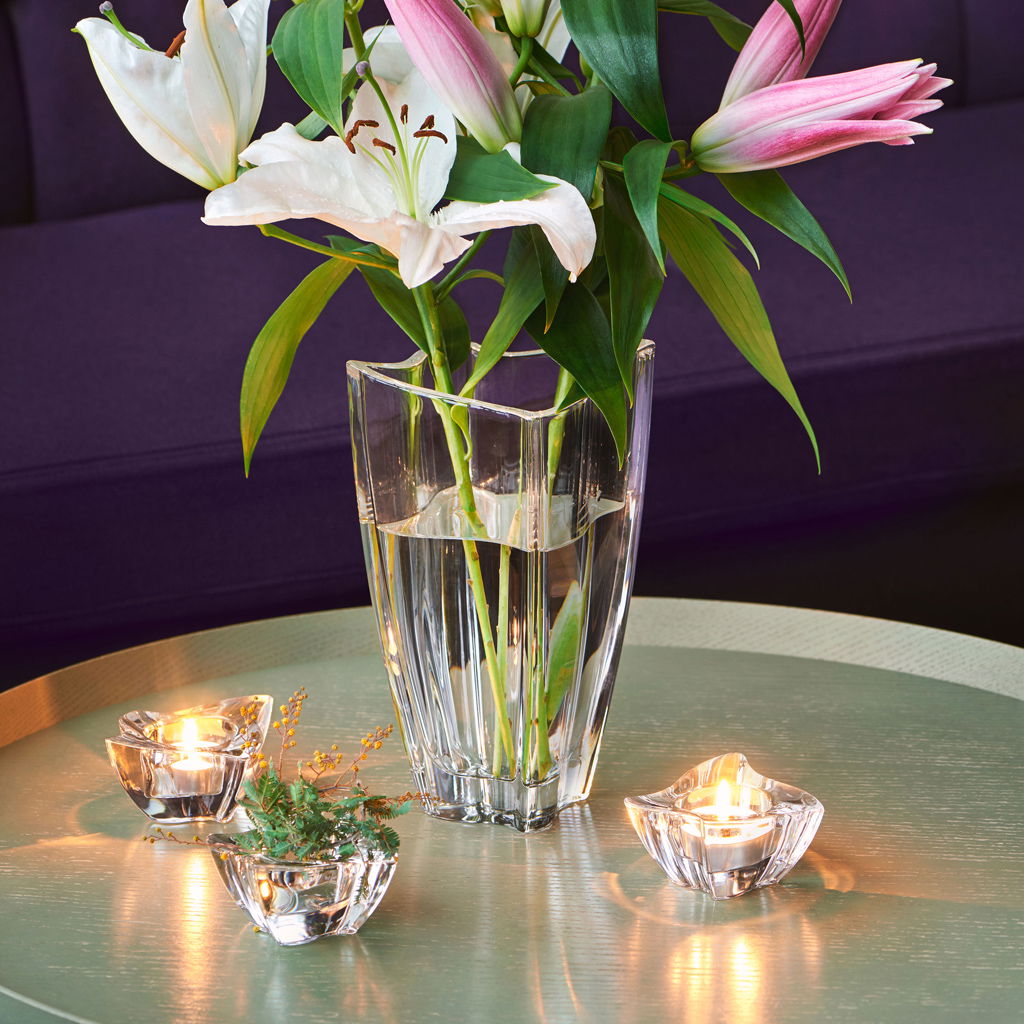 Blumenstrauß in einer Vase und Teelichter auf einem Tisch