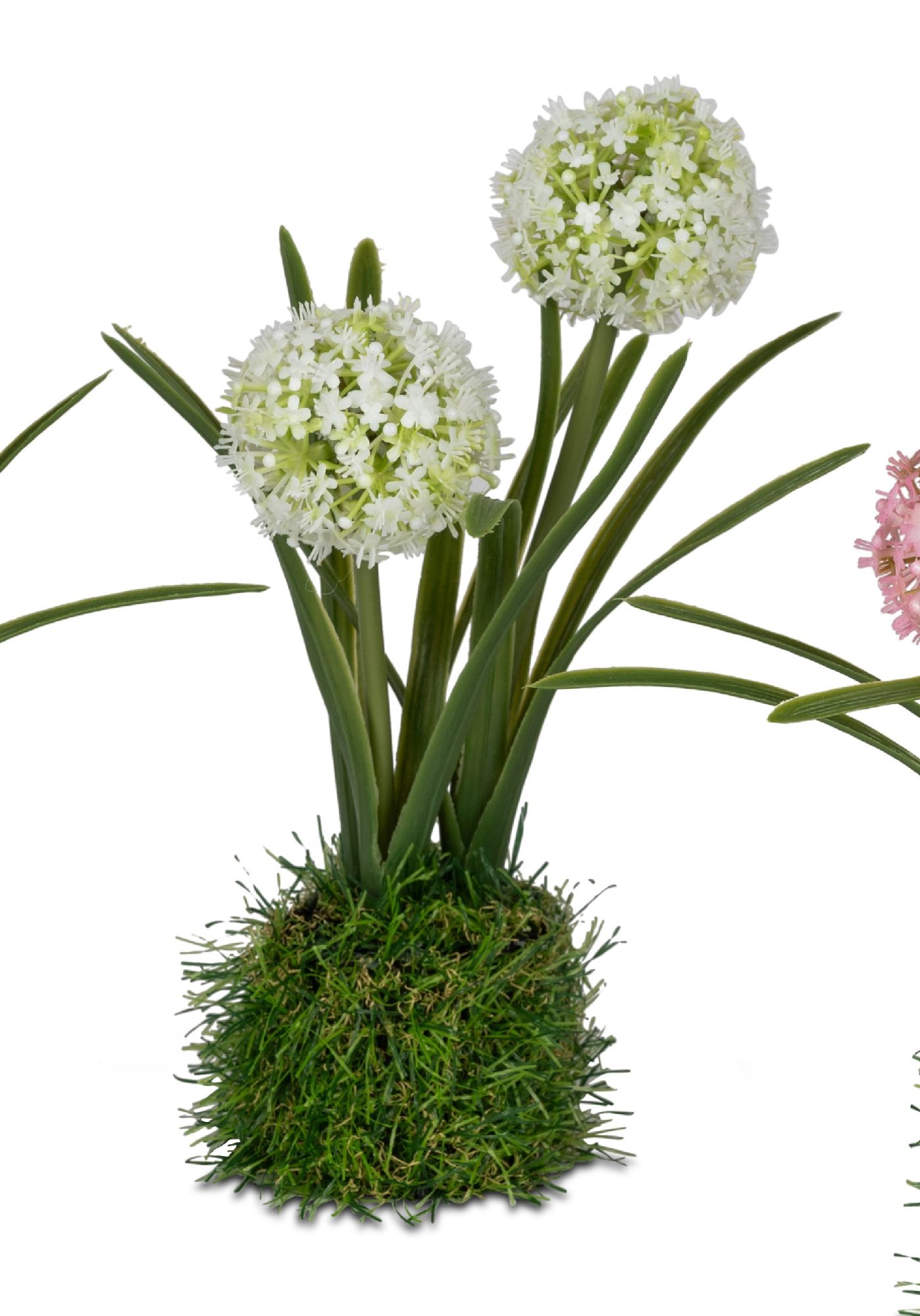 Künstliche Blumen in weißen und rosa Farbtönen, mit langen grünen Stängeln und einer grasähnlichen B