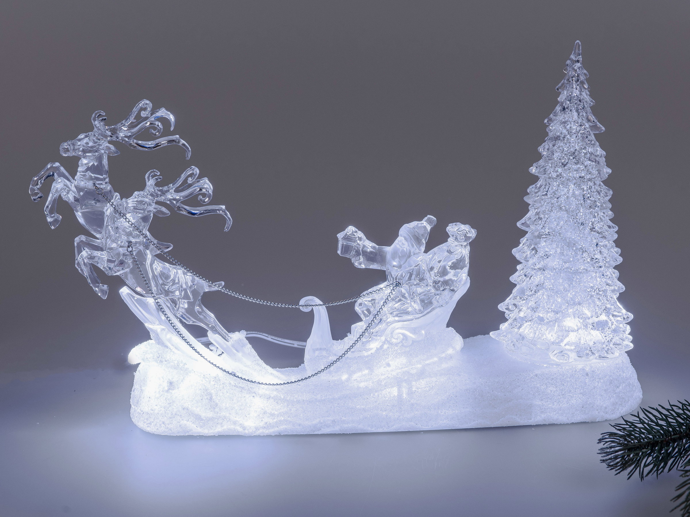 Dekorative Figur aus klarem Material mit einem Schlitten, Rentieren und einem Weihnachtsbaum, beleuc