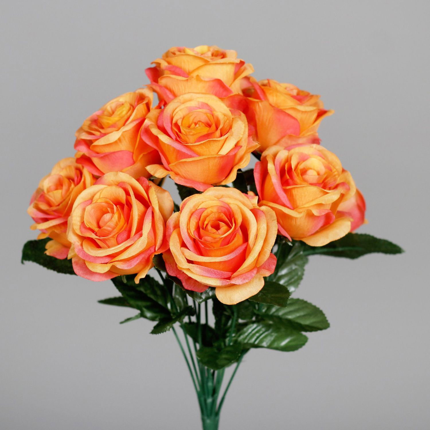 Strauß aus orangegelben Rosen mit grünen Blättern vor grauem Hintergrund