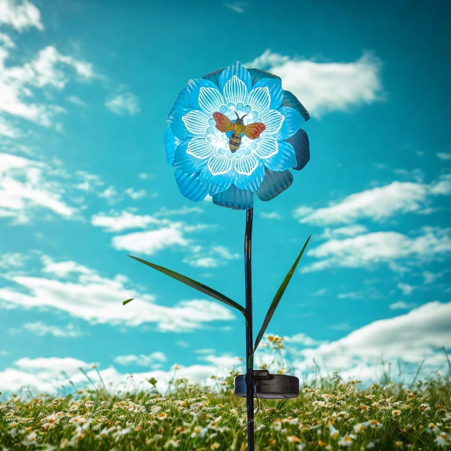Dekorative Blume mit Bienenmotiv auf Wiese unter blauem Himmel mit Wolken