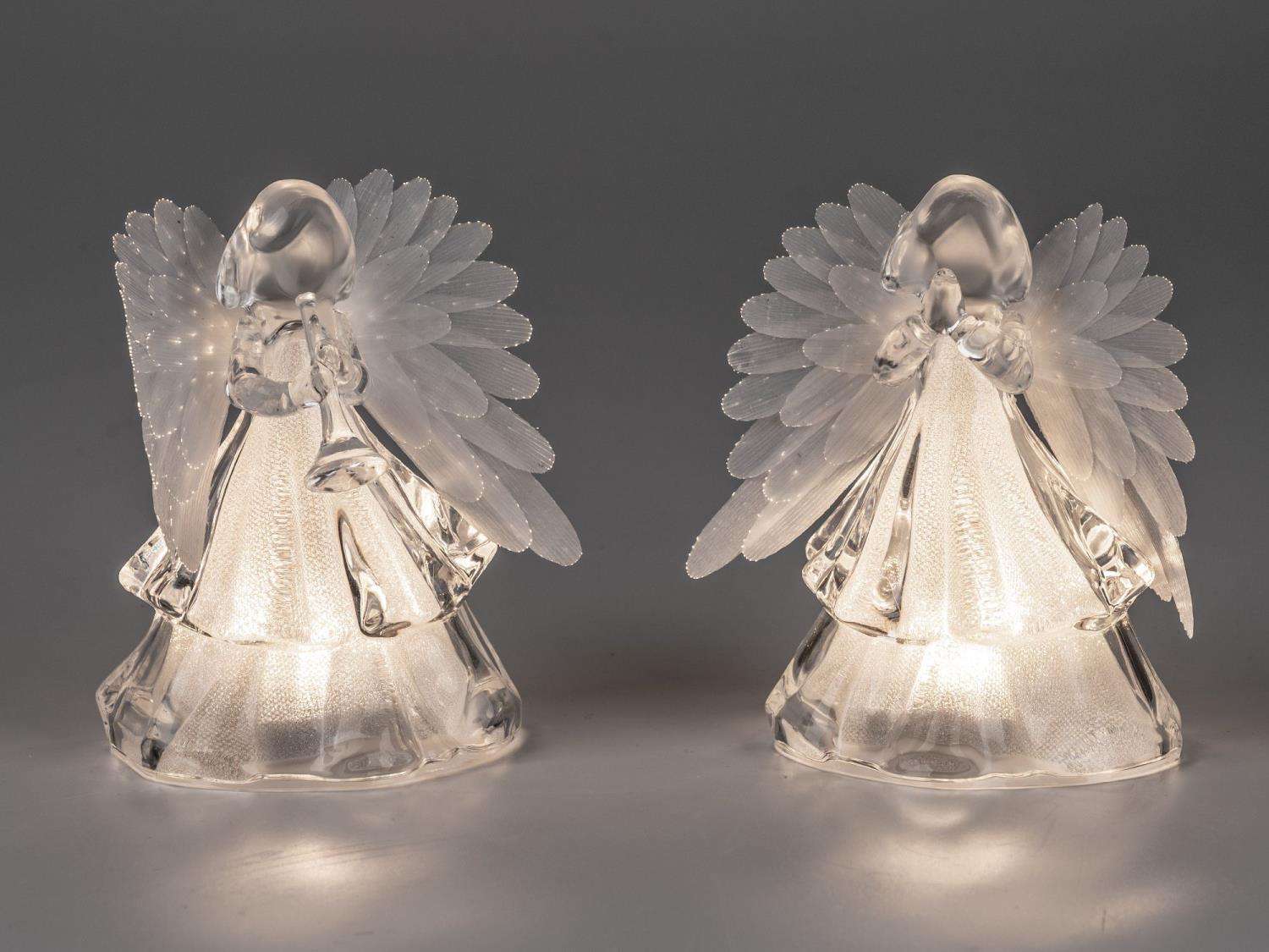 Zwei gläserne Engel mit transparenten Flügeln stehen nebeneinander und leuchten sanft von innen.