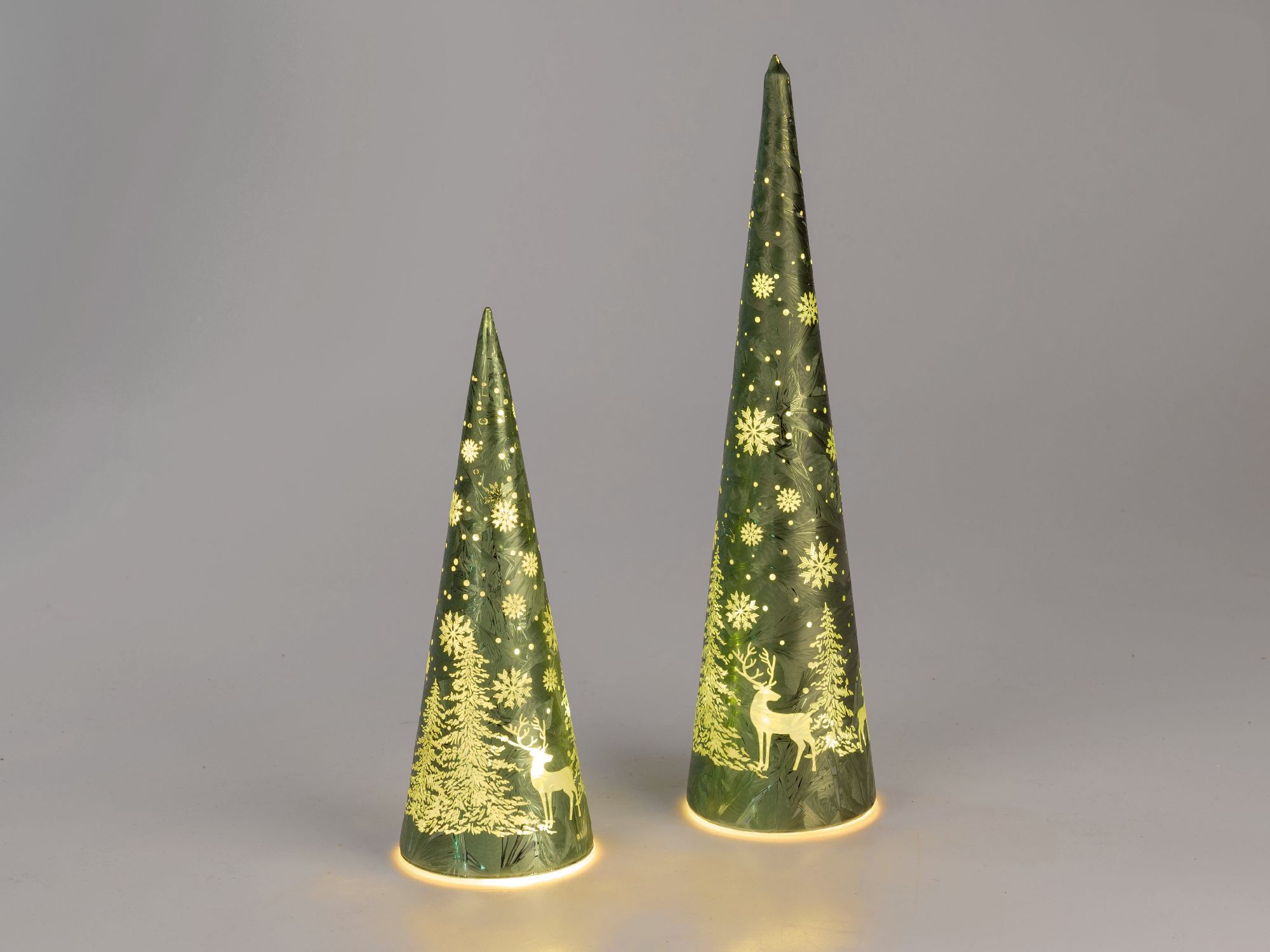 Zwei grüne, beleuchtete Weihnachtsbaum-Dekorationen in Kegel-Form mit Schneeflocken und einem Reh-Mo