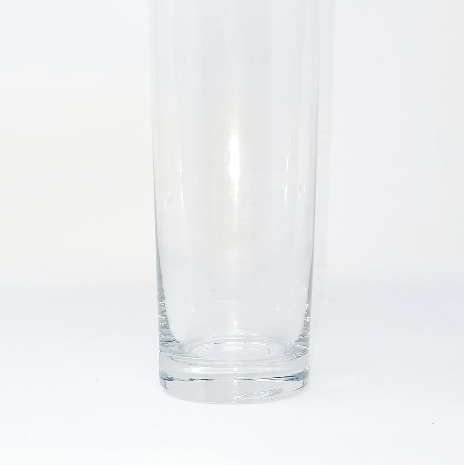 Ein transparenter, hoher Glasbecher mit geradem Rand und stabiler Basis auf weißem Hintergrund.
