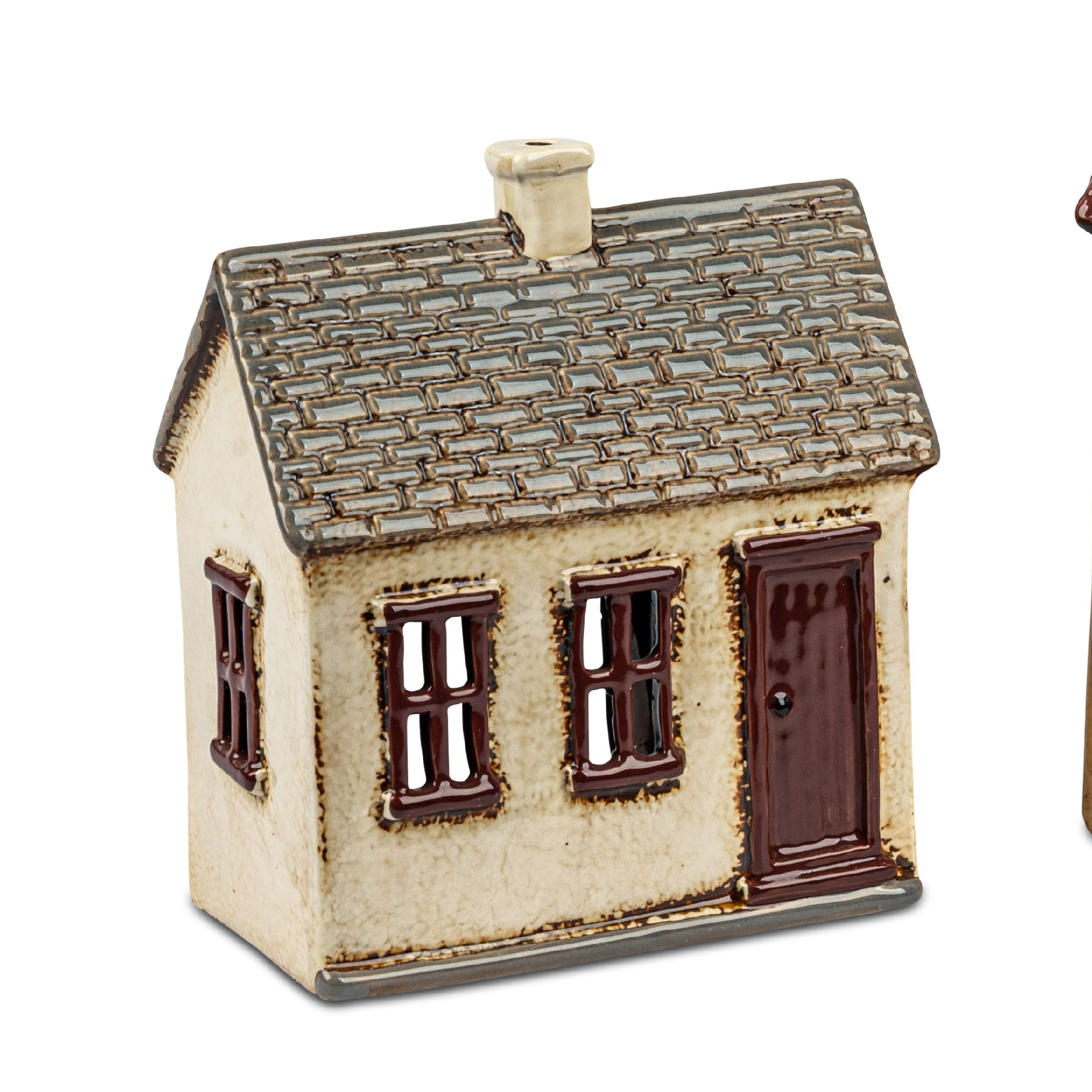 Keramisches Haus mit braunen Fenstern und Tür, schiefergrauem Dach und Kamin. Rechts steht ein weite