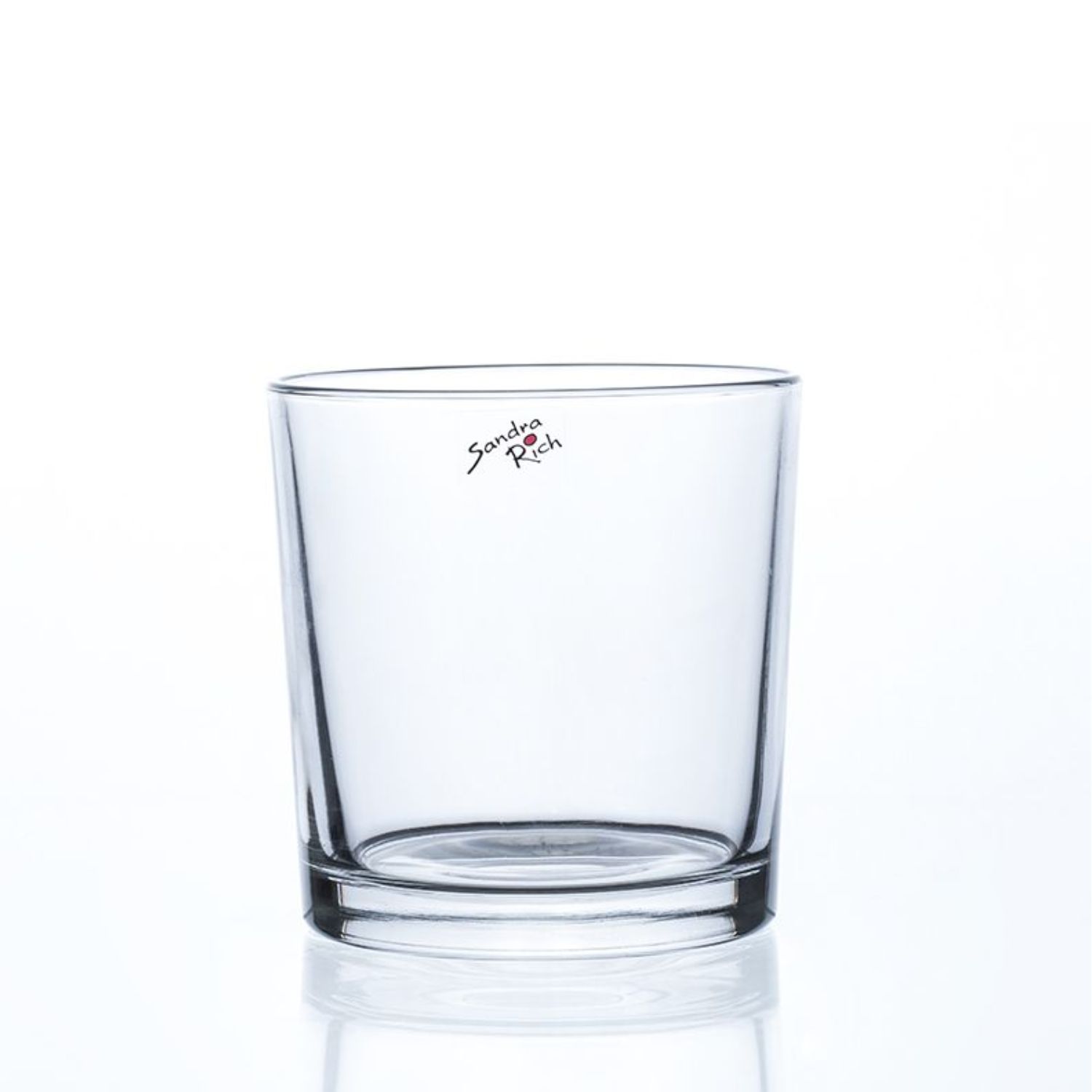 Ein transparenter Glasbecher steht auf einer reflektierenden Oberfläche. Er hat eine gerade Form und einen stabilen Boden.