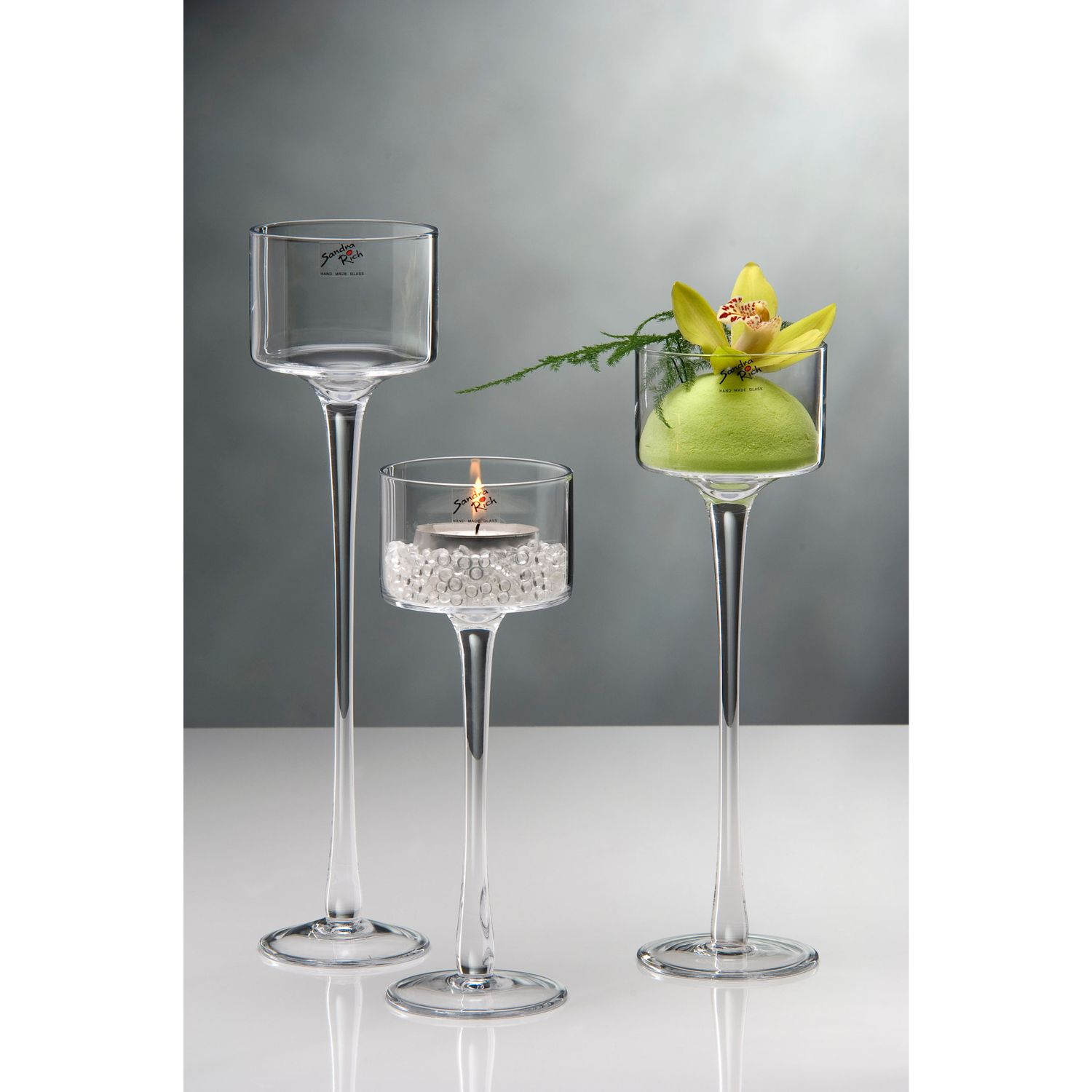 3 Teelichthalter auf Fuß aus transparentem Glas mit Kerze und Blume dekoriert