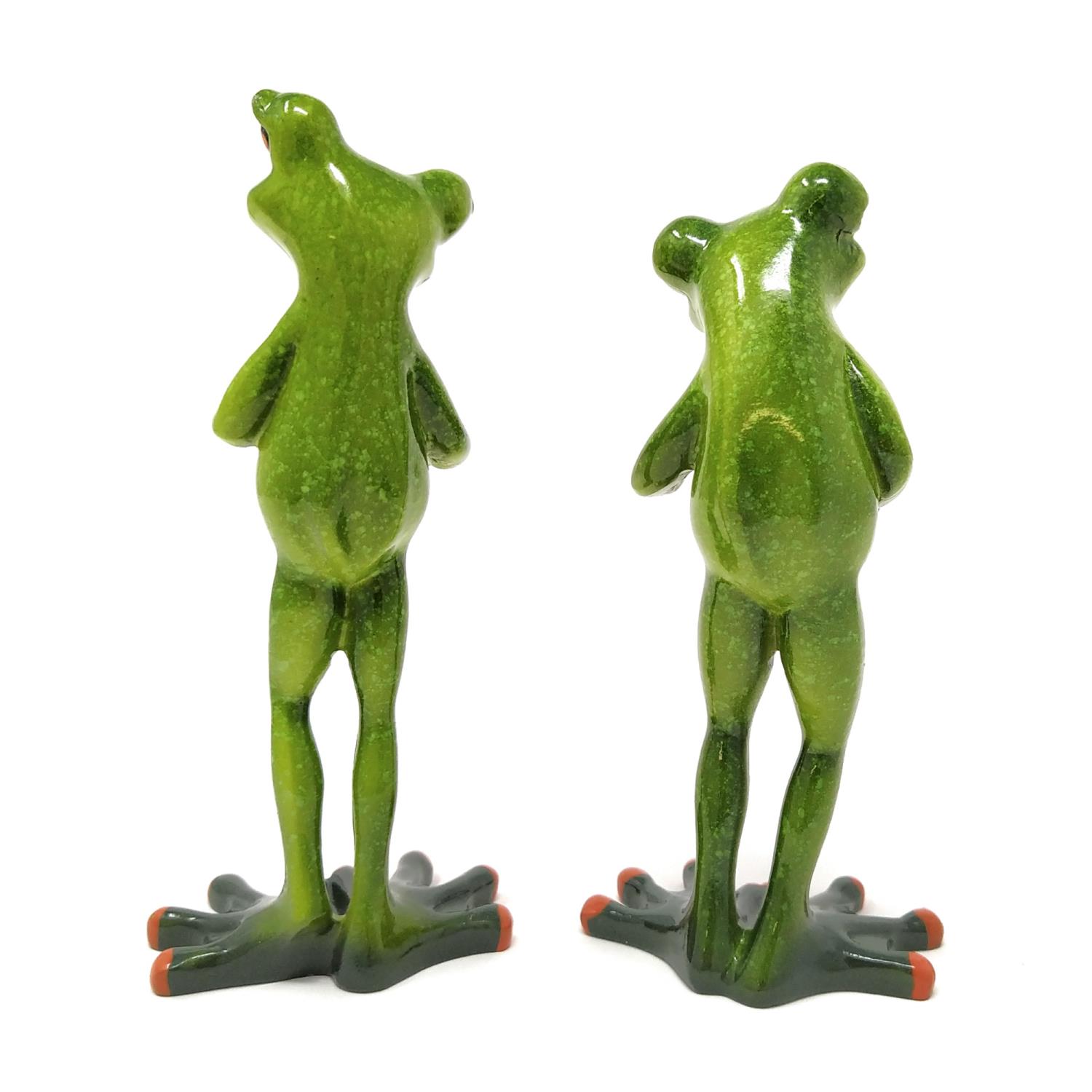 Zwei grüne Froschfiguren stehen nebeneinander. Sie sind aus Keramik und haben orangefarbene Details an den Füßen.