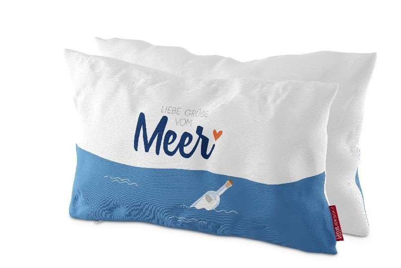Zwei Kissen mit einem weißen und blauen Design. Auf einem Kissen steht der Text „Liebe Grüße vom Meer“ und eine Flasche im Wasser.