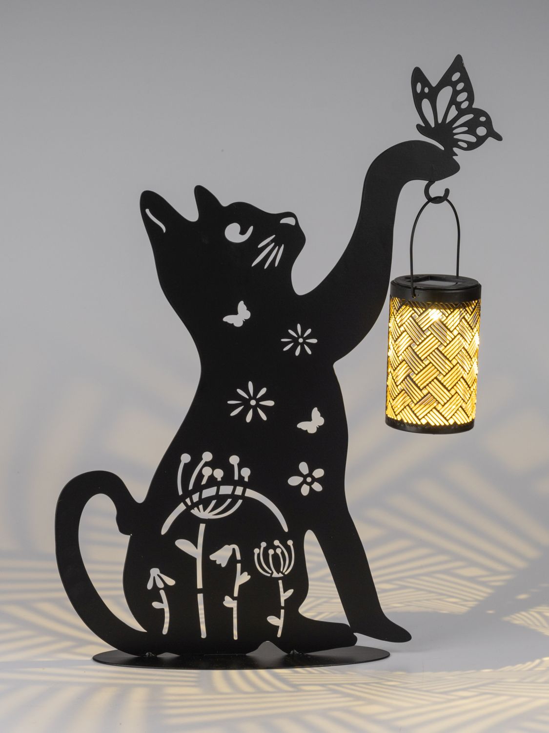 Schwarze Katzensilhouette mit Schmetterling und hängender leuchtender Laterne
