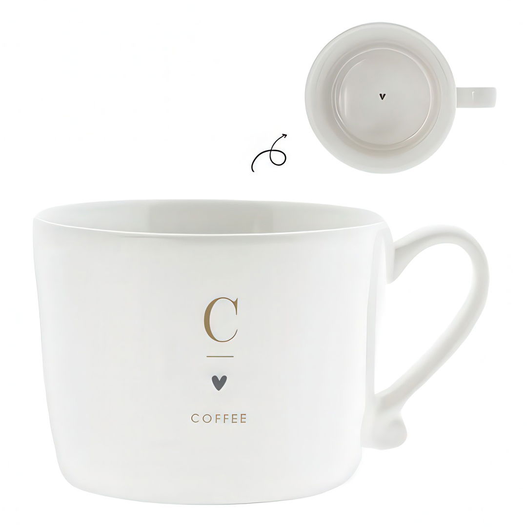 Weiße Kaffeetasse mit goldener Schrift „C“ und „COFFEE“ sowie einem Herzsymbol. Die Tasse hat einen Henkel und eine runde Form.