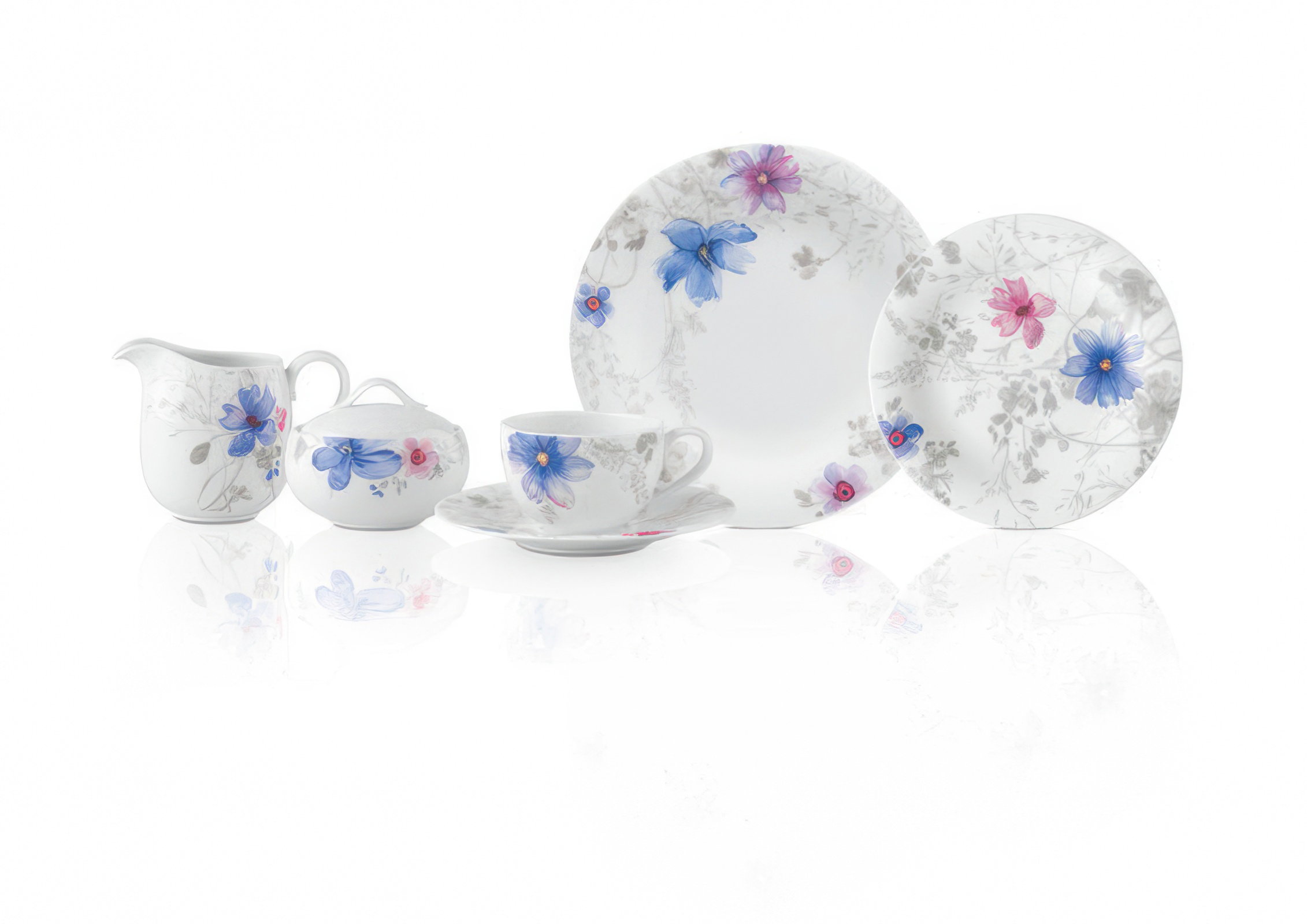Ein Set aus Porzellan mit einer Tasse, Untertasse, Zuckerdose, Milchkännchen und zwei Tellern, verziert mit blauen und rosa Blumen.