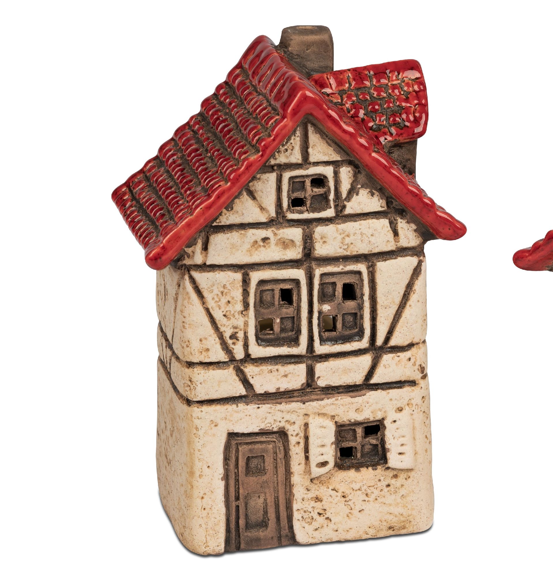 Ein kleines, dekoratives Haus aus Keramik mit rotem Dach und braunen Fensterrahmen. Die Fassade ist beige mit schwarzen Linien.